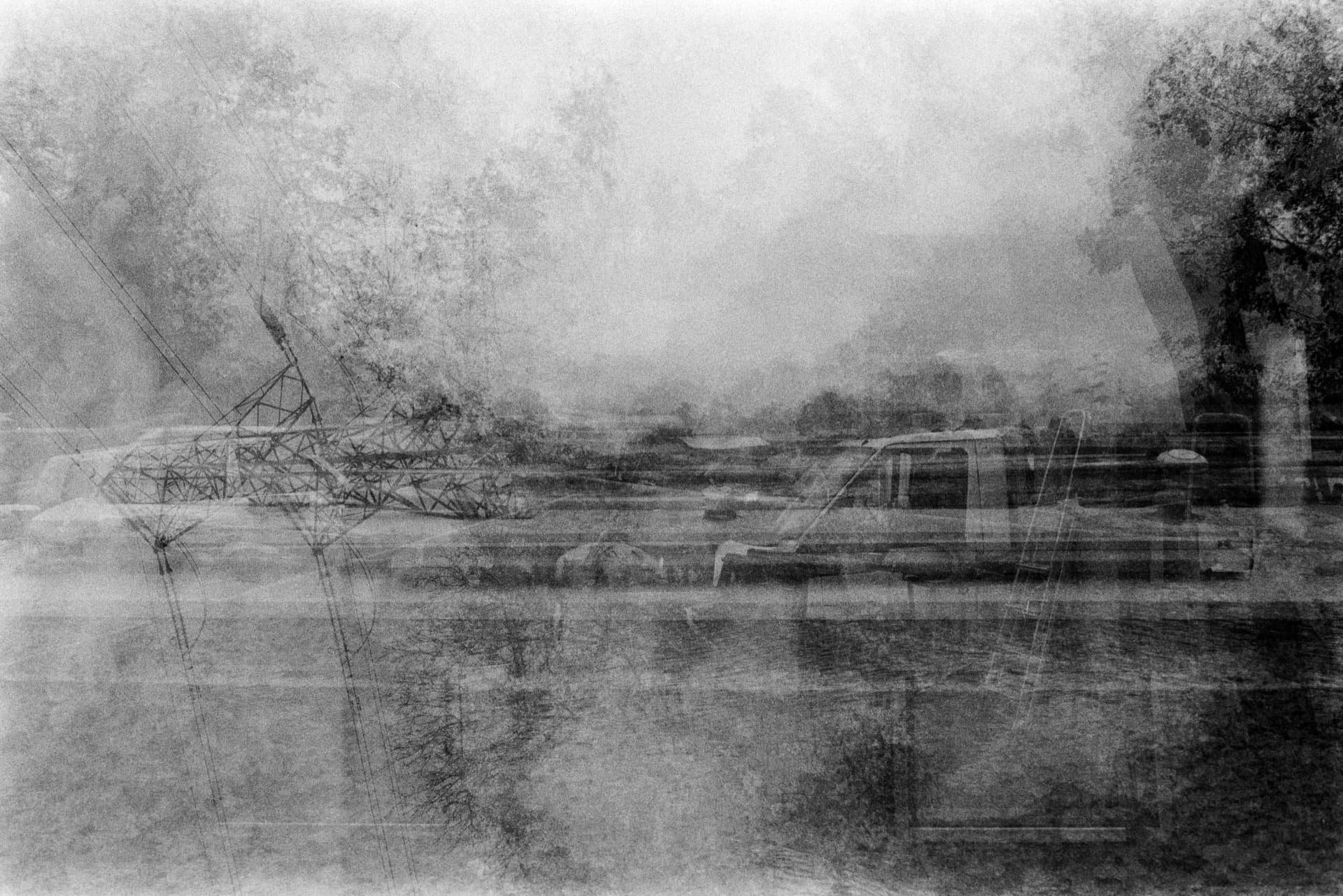 Multiple exposure of power pylons, canal boats, and misty landscape along waterway