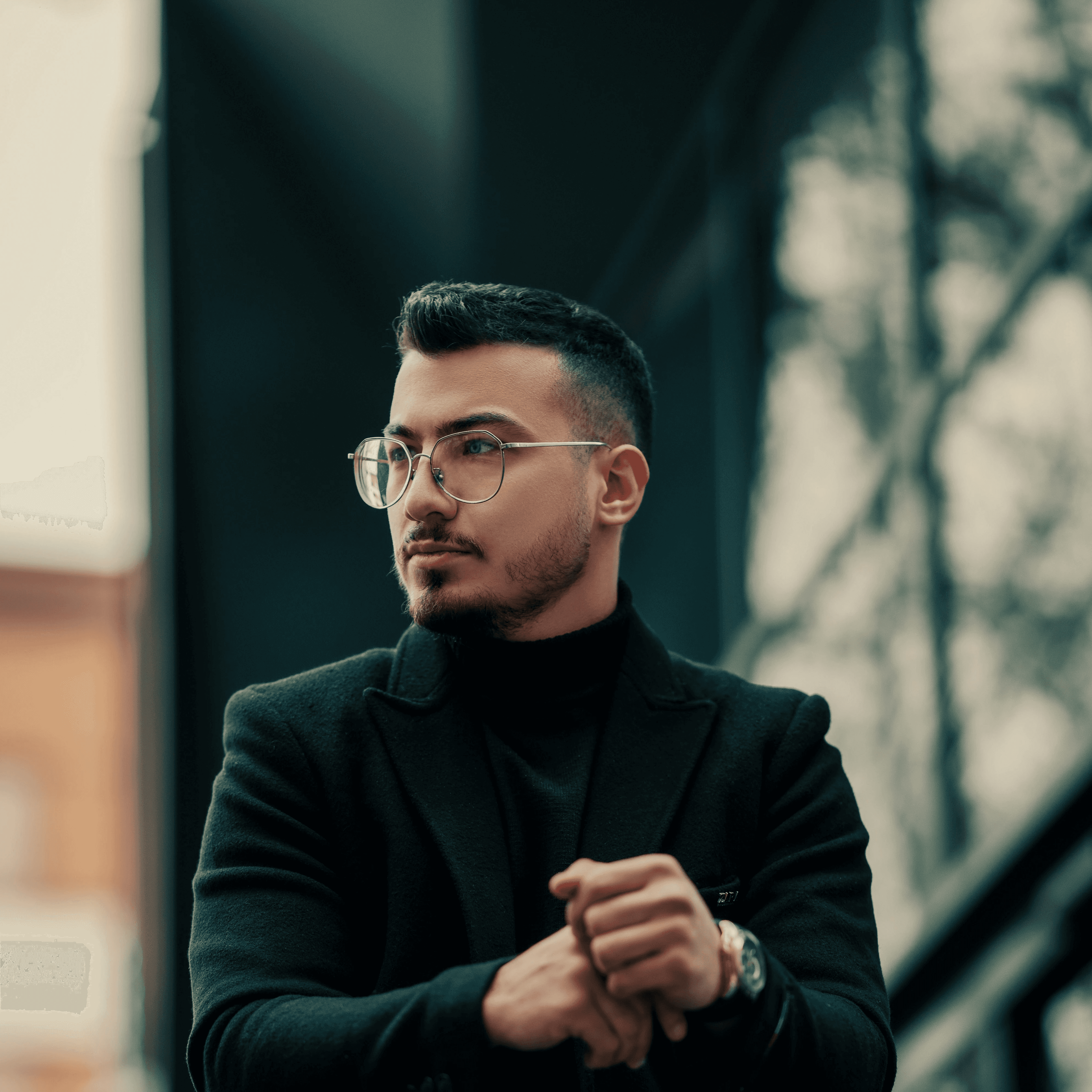 a man standing on a balcony with his arms crossed
