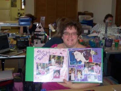 Woman showing a two-page scrapbook spread with purple accents