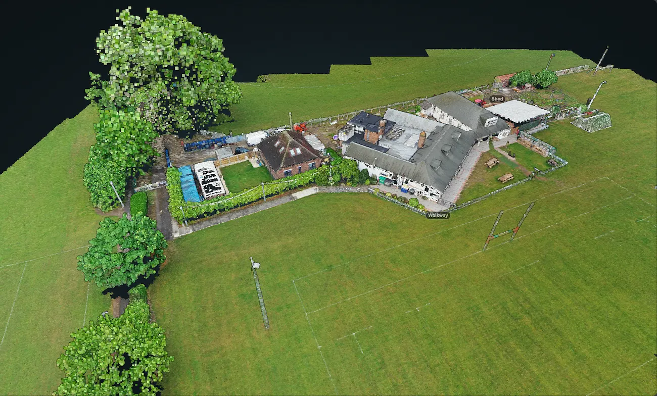 3D point cloud model visualization of a building complex and sports field on a black background