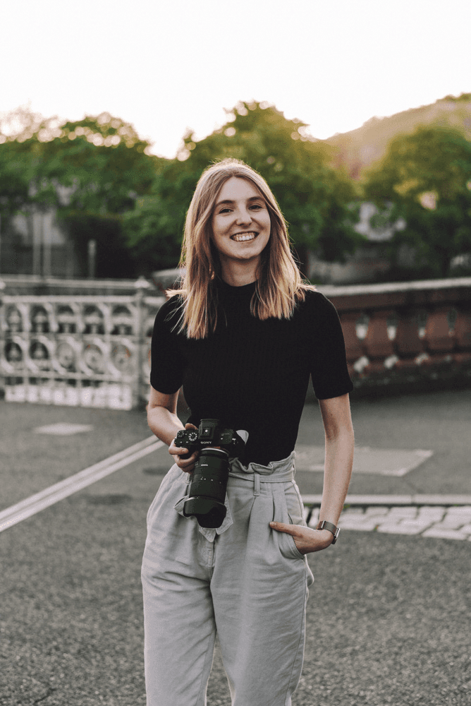 Lifestyle Phoographer Lara Slevec holding a glass and smiling at the camera.