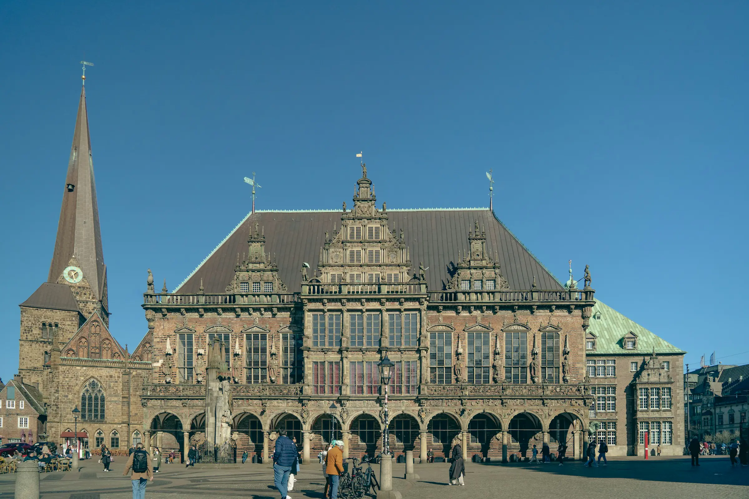 Bremen, historisches Rathaus mit Dom-Turm am Marktplatz unter klarem blauen Himmel (UNESCO-Welterbe)