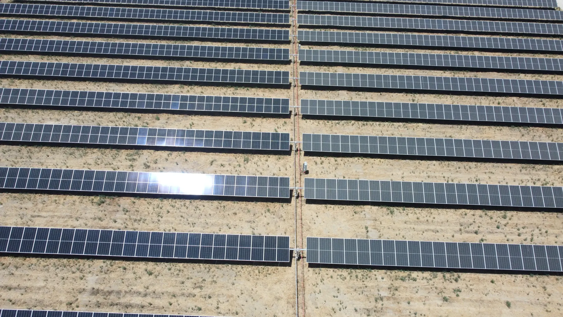 Drone view straight down on rows of ground-mount solar panels at a commercial site in Fresno, CA
