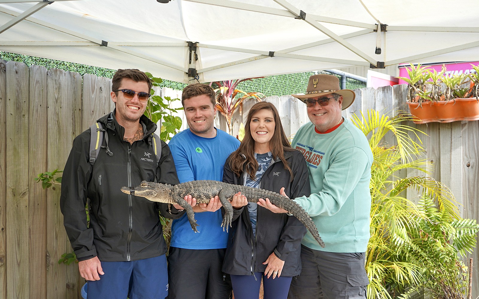 Guests holding a small alligator at Everglades Holiday Park animal encounter.
