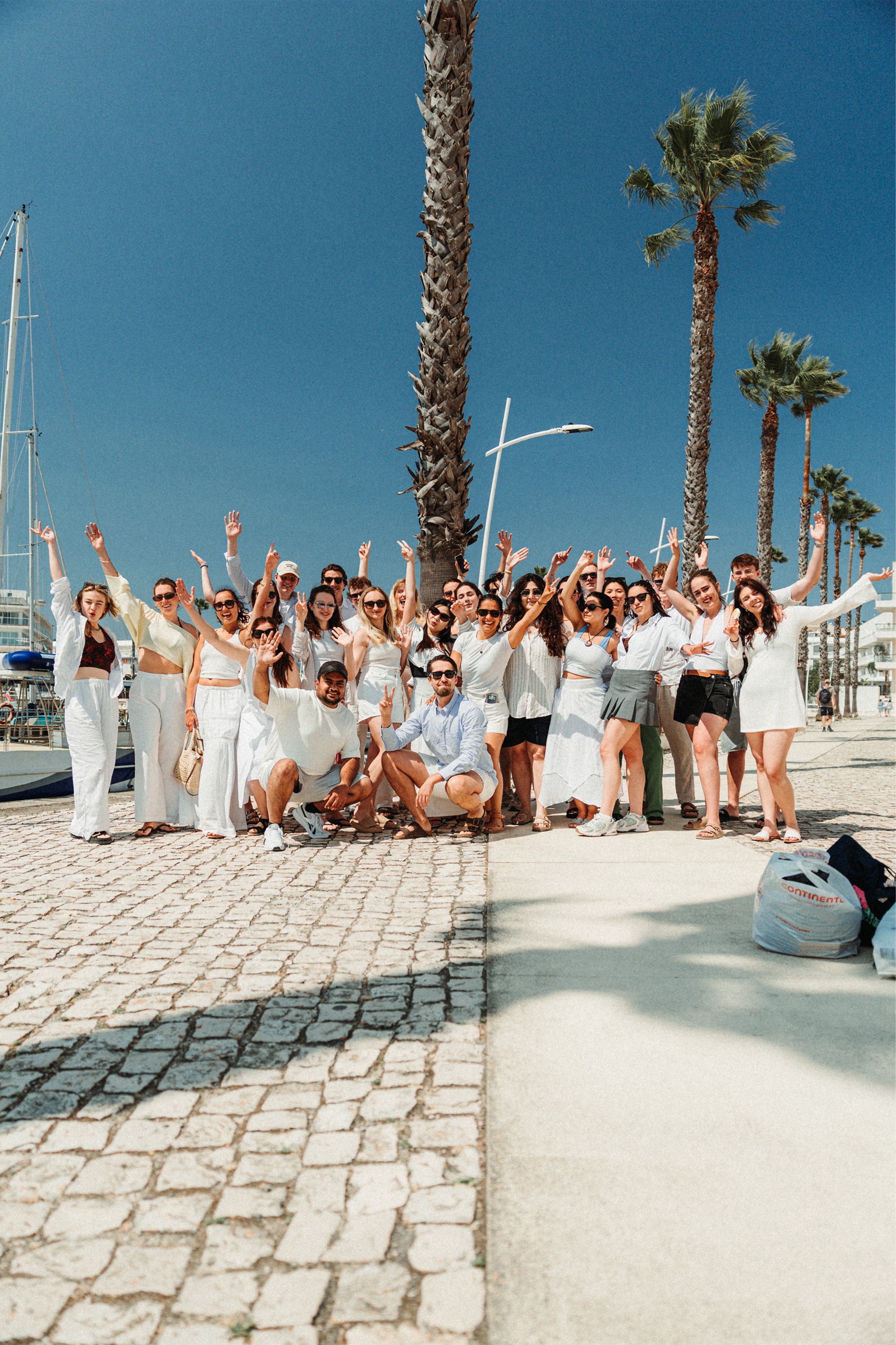 A person in an office smiles while talking on the phone, surrounded by paperwork and office supplies.