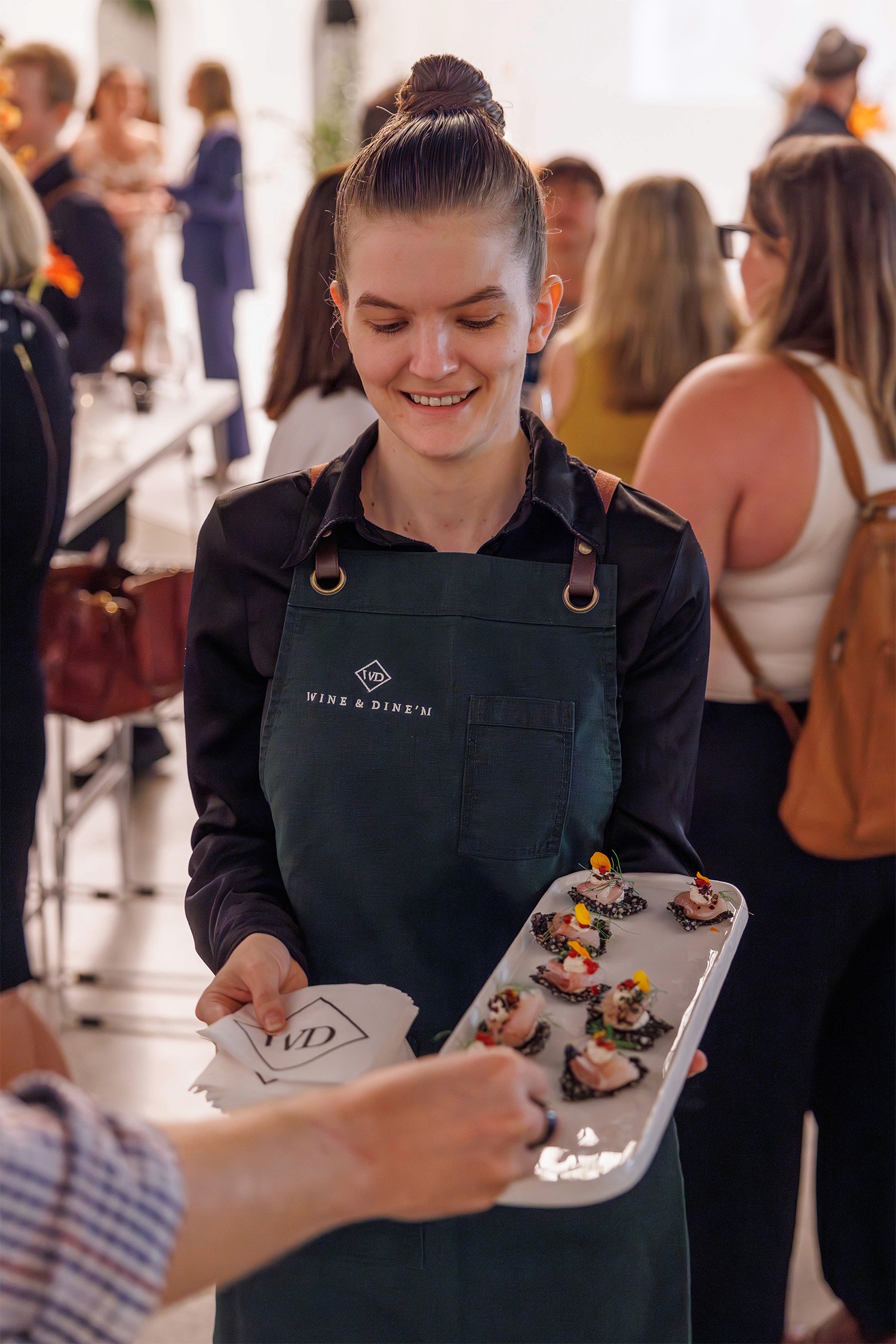 Waiter serving kingfish canape to guests