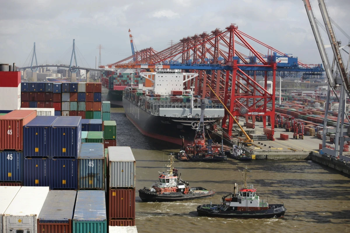 Cargo ship and tugboats in harbor with containers