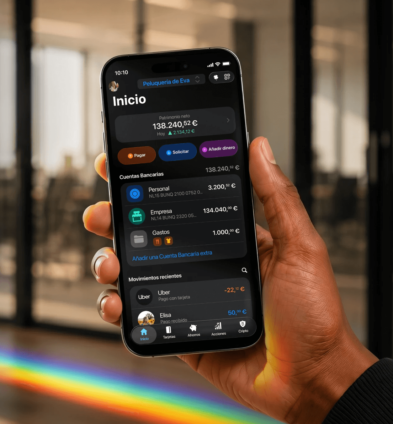 Persona realizando un pago con tarjeta «contactless» con un smartphone en el terminal de un bar