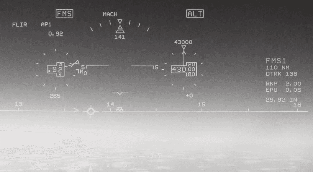 A black and white image depicting a blurred landscape with faint, ambiguous shapes in the foreground and background.