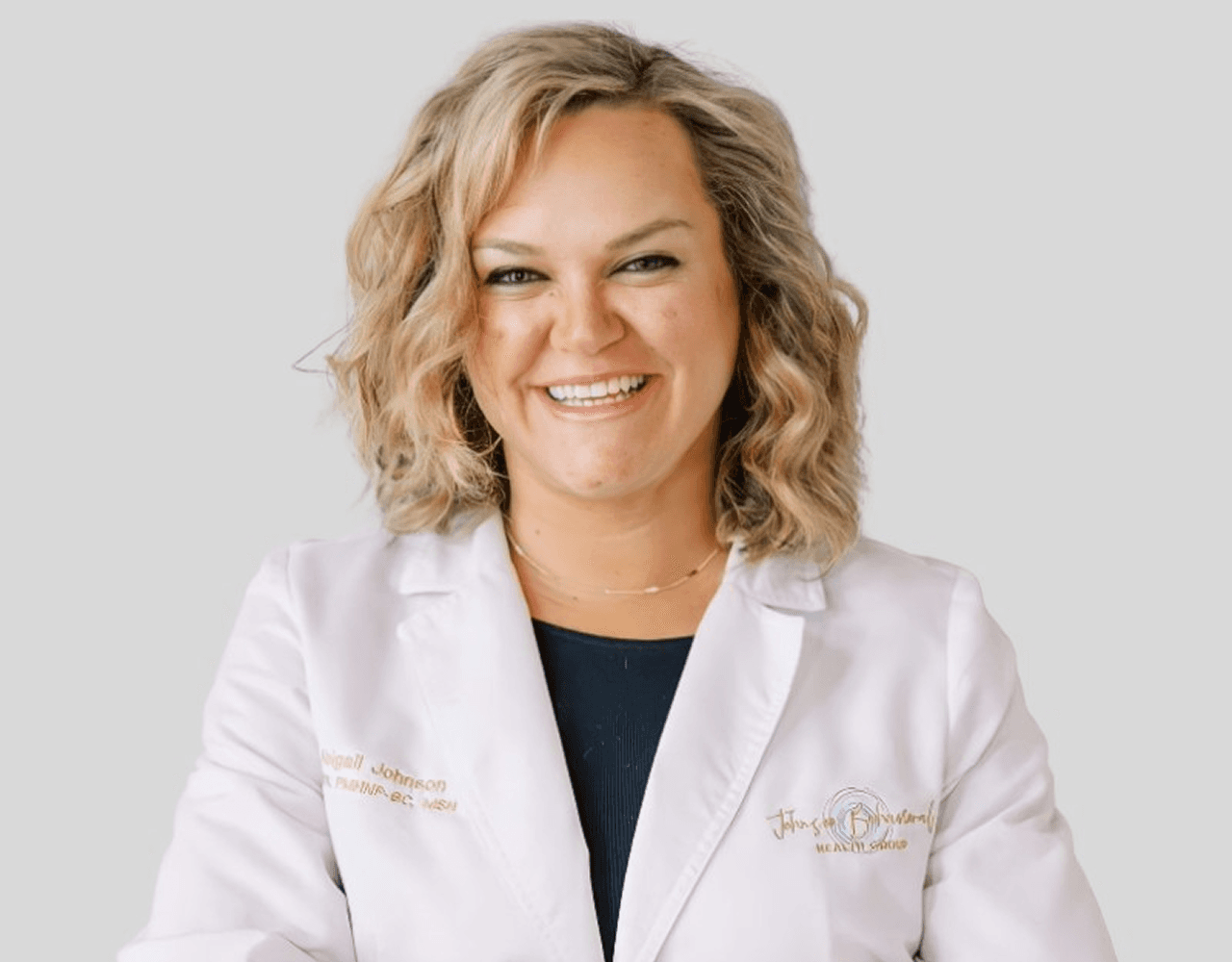 a woman in a white lab coat pointing at something