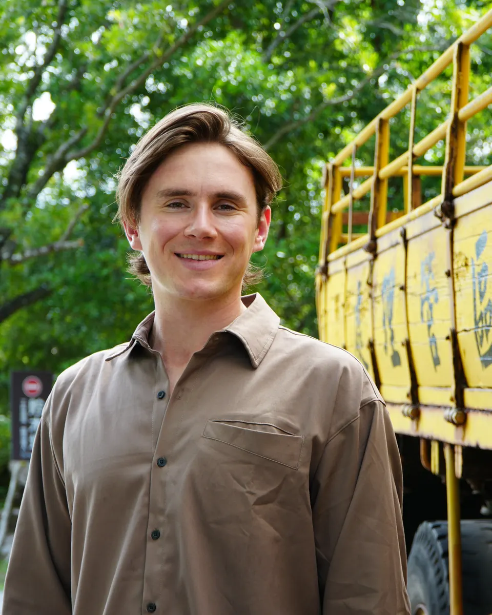 Jude Massey smiling beside a yellow truck