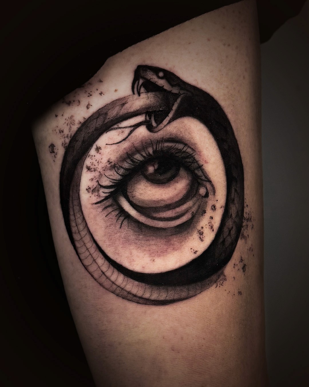 Illustrative black and white tattoo of a snake and eye by lifecyclz