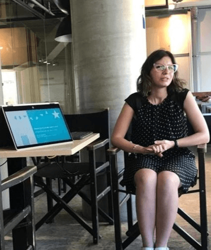 Silvia Vazzana è seduta e mostra una presentazione al computer