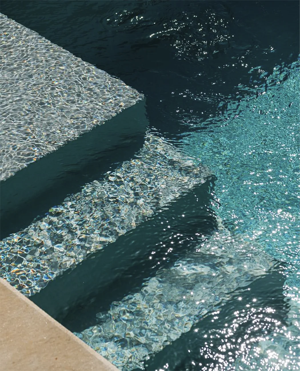 Detalhe dos degraus e da água de uma piscina Garden com acabamento premium