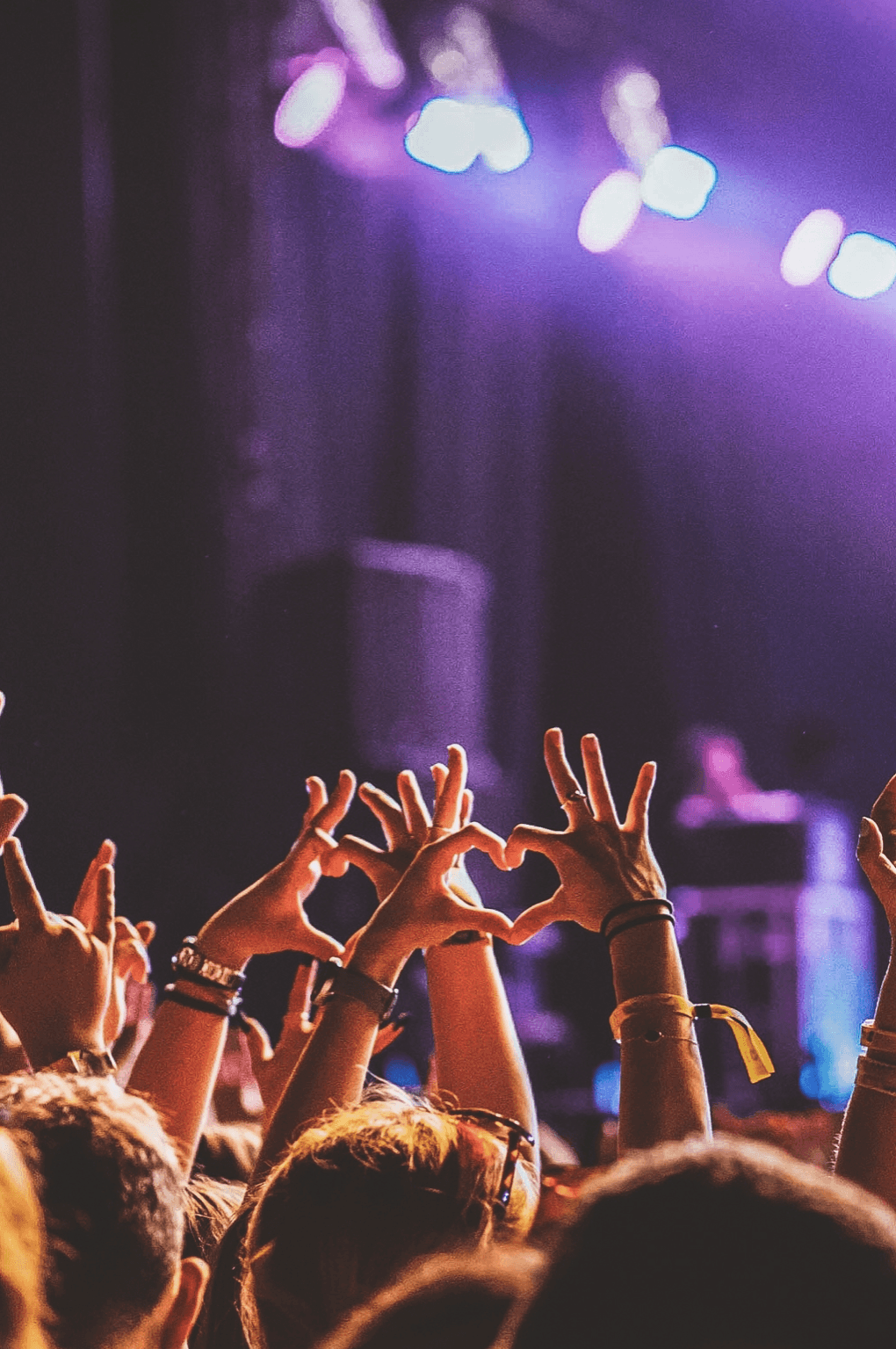 Fans showing love signs at concert