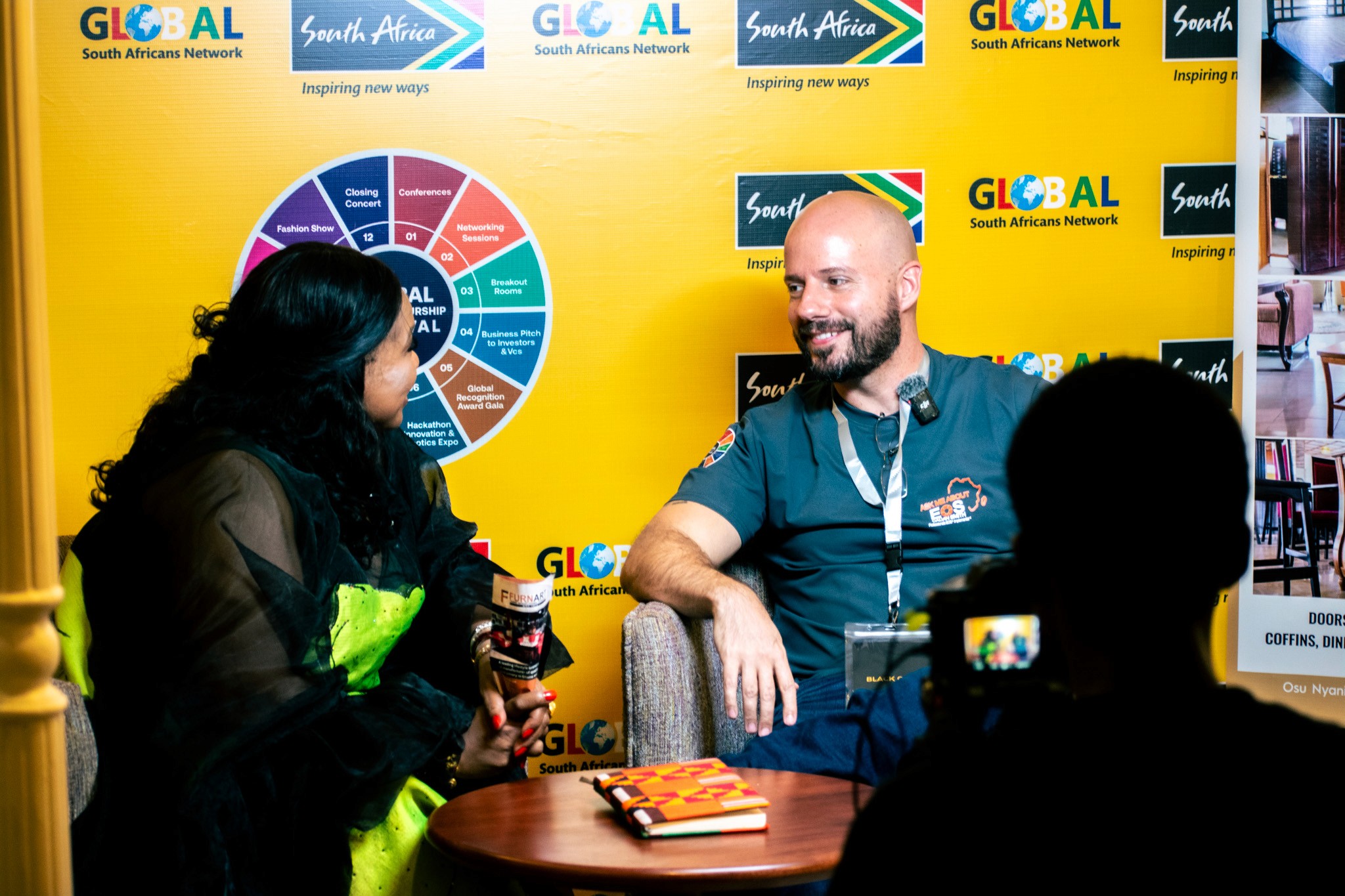 A minimalist wooden desk with a small lamp and an open notebook, situated in a bright, warm-lit room.