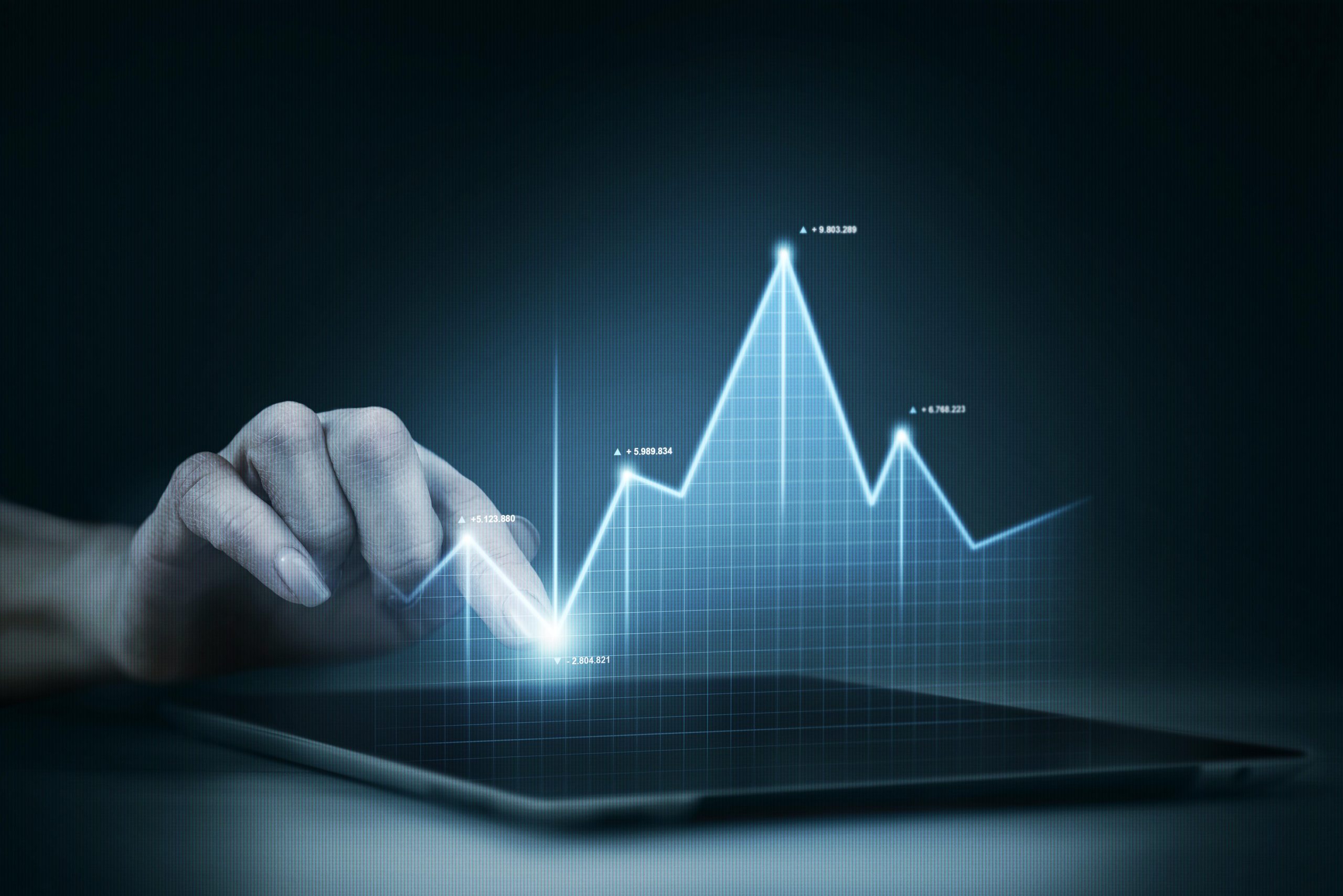 A hand interacting with a digital tablet displaying a glowing graph with data points, representing growth, data analysis, and technological advancements in marketing trends.