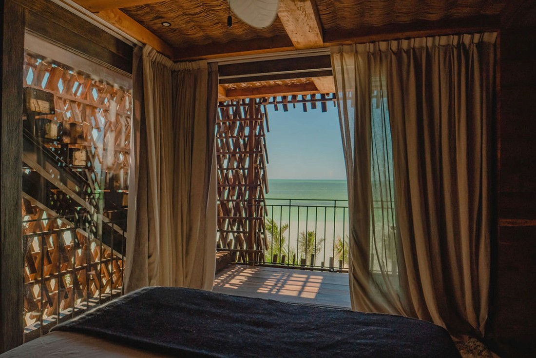 Experience the ultimate in beachfront luxury with the oceanfront suite at Nomade Holbox in Holbox Mexico, featuring a spacious living area and state-of-the-art amenities