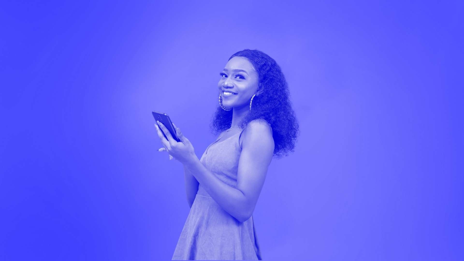 A woman smiling and holding a phone