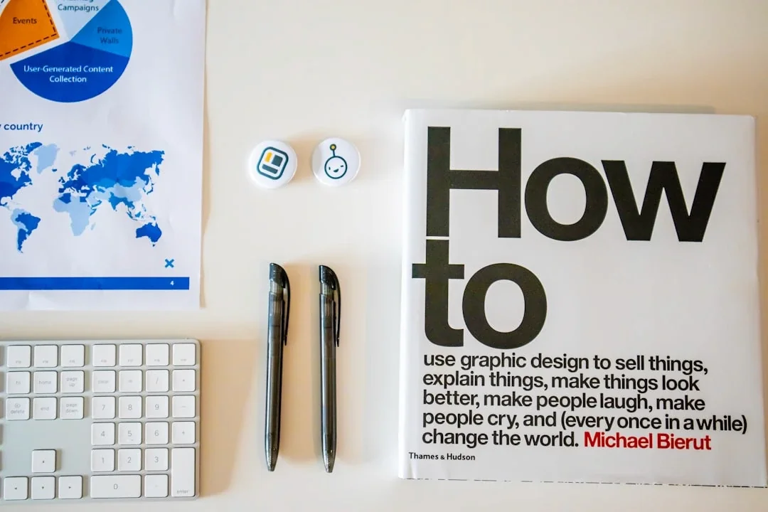 a magazine sitting on top of a desk next to a keyboard