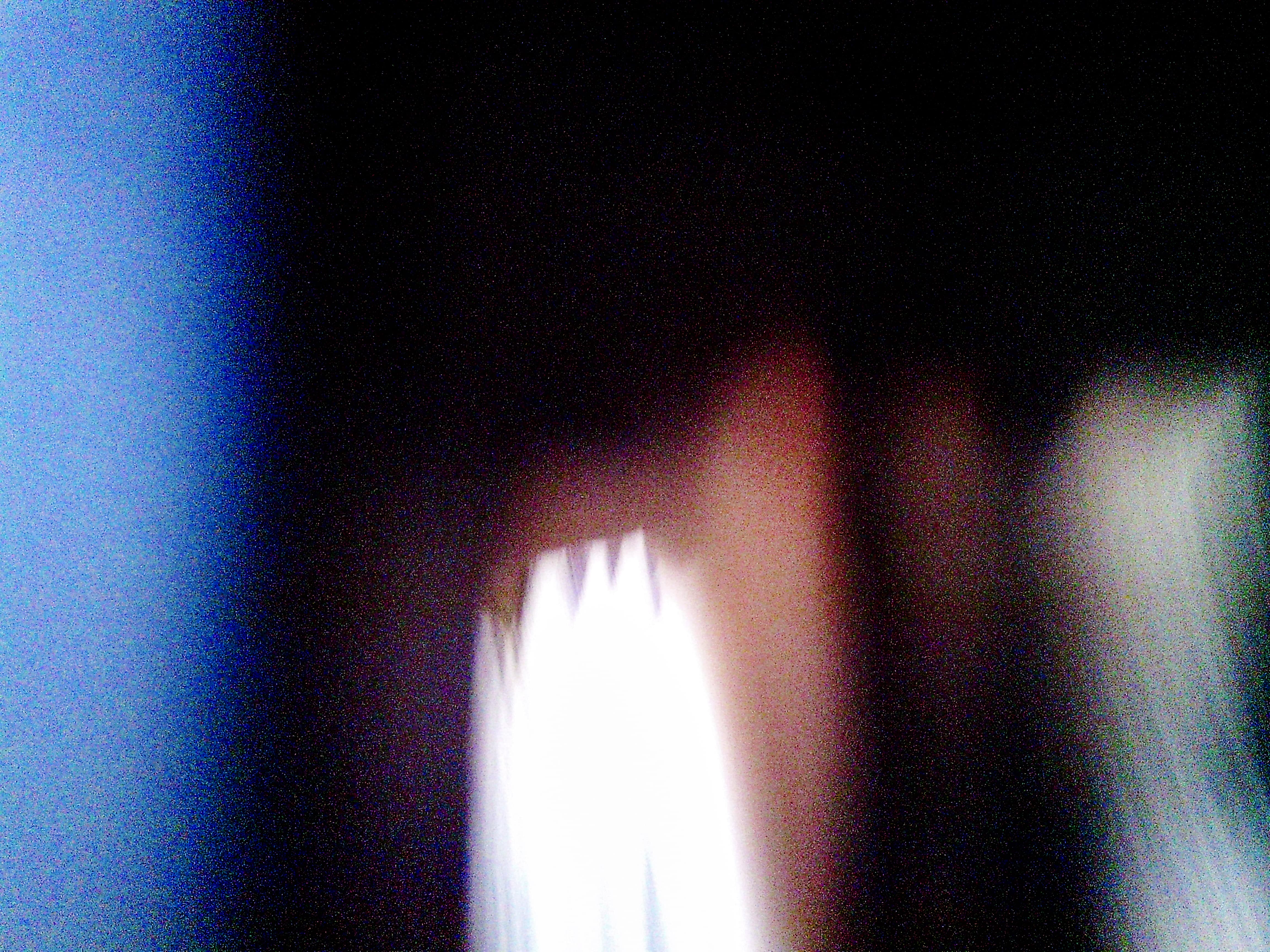 Bright rectangular light source surrounded by heavy chromatic aberration and digital noise