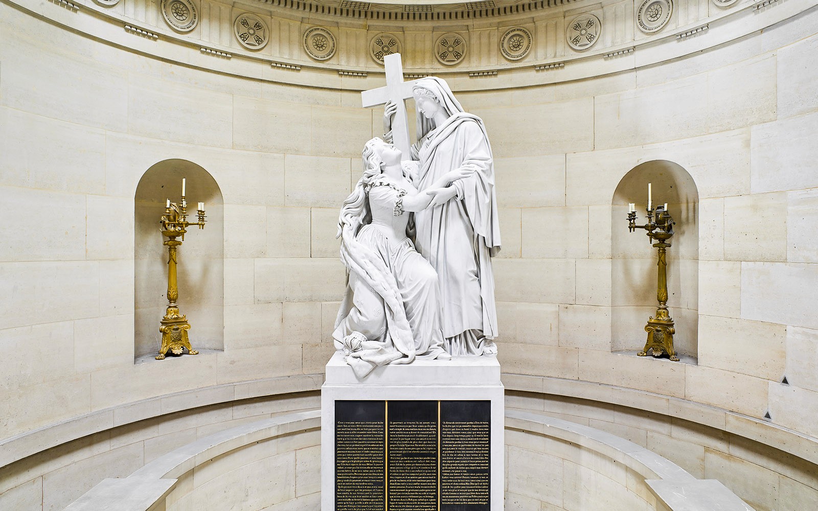 巴黎赎罪礼拜堂内的雕像，描绘了一位跪着的雕像，手持十字架。