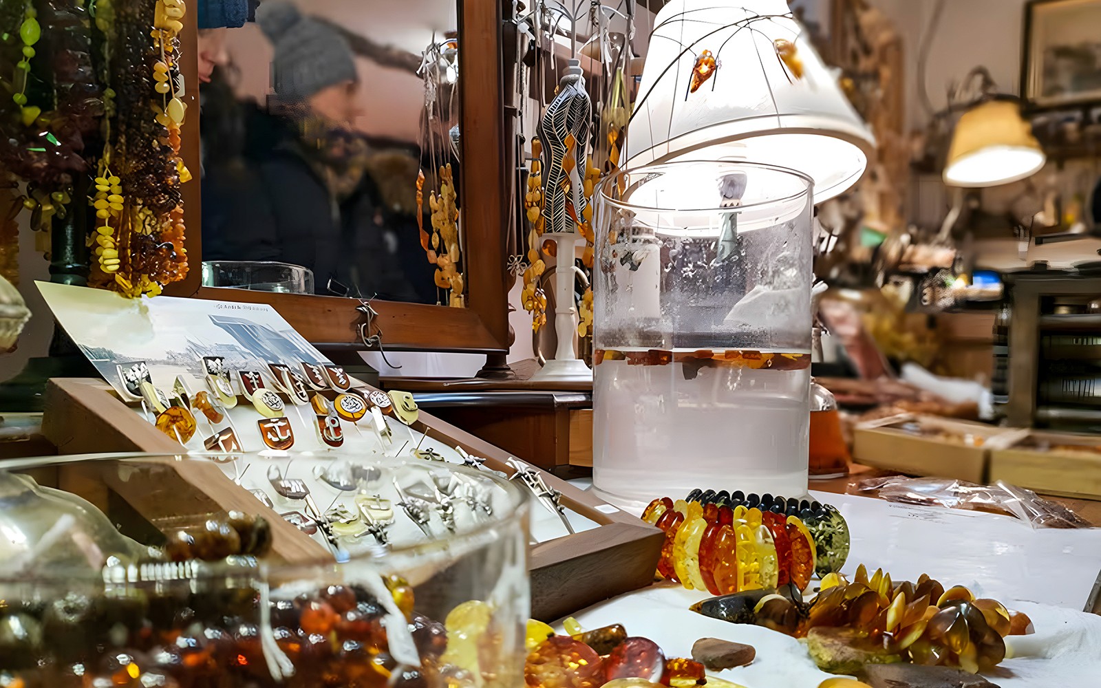 Amber jewelry display at Gdańsk workshop with necklaces and rings.