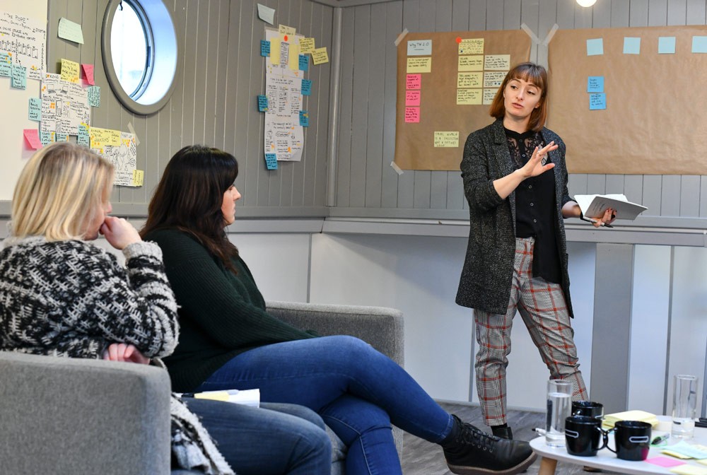 Alex Durussel-Baker facilitating a design sprint in a room full of postit notes