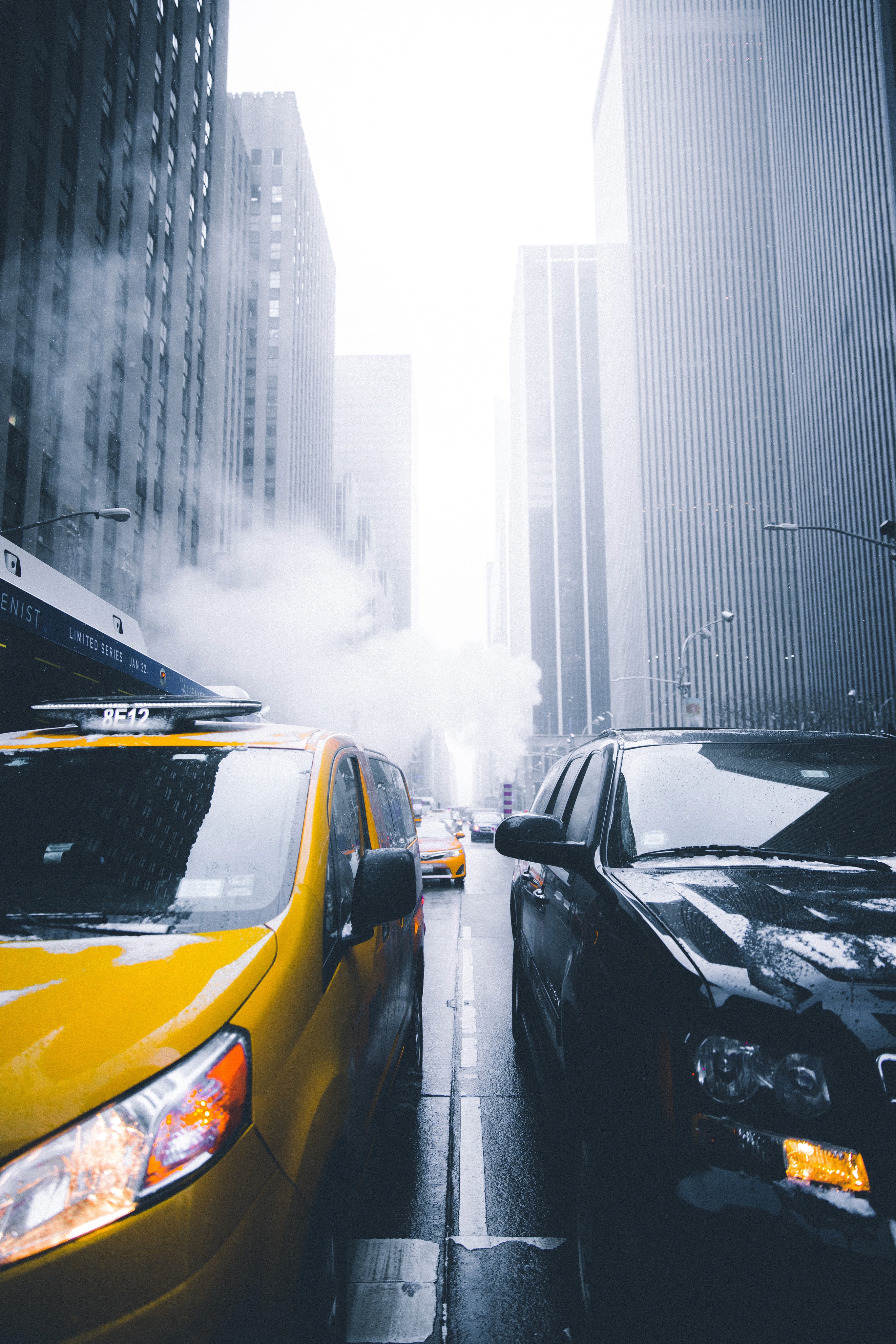 City street filled with traffic next to tall buildings