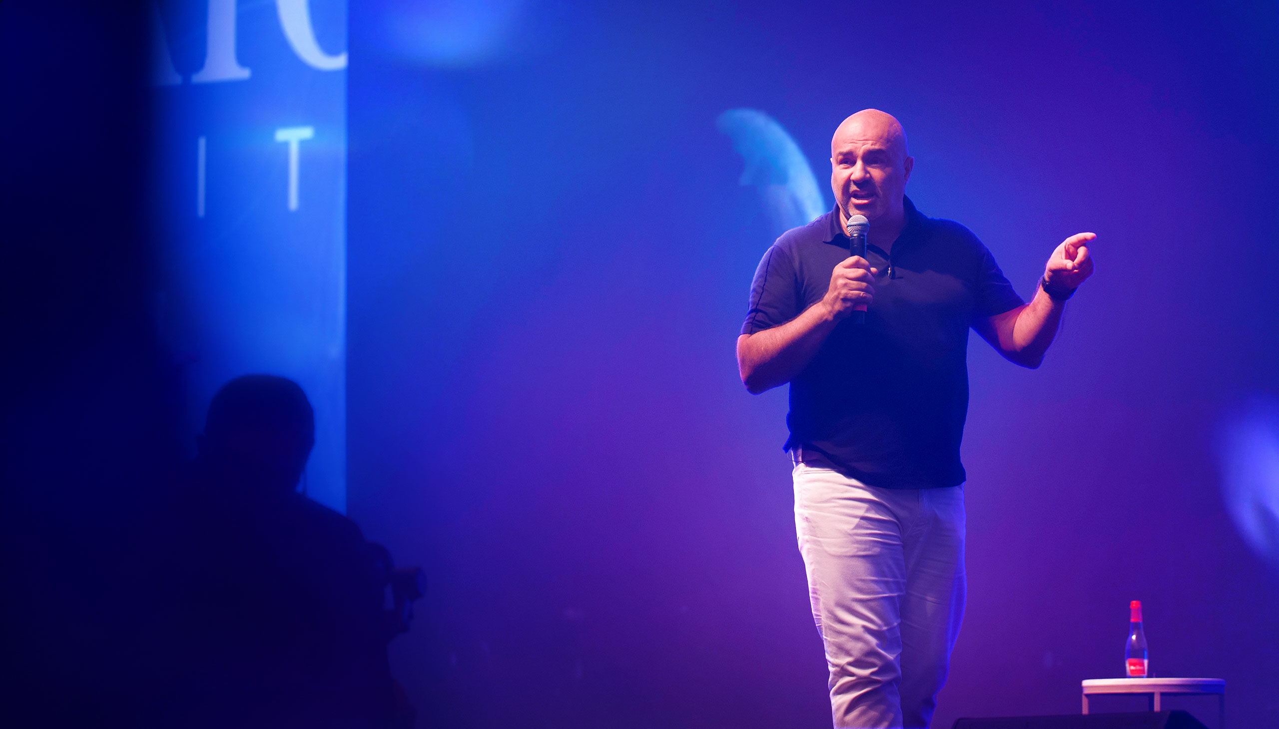 Dariush Soudi speaking on stage at Gladiator Summit in Dubai sharing entrepreneurship principles.