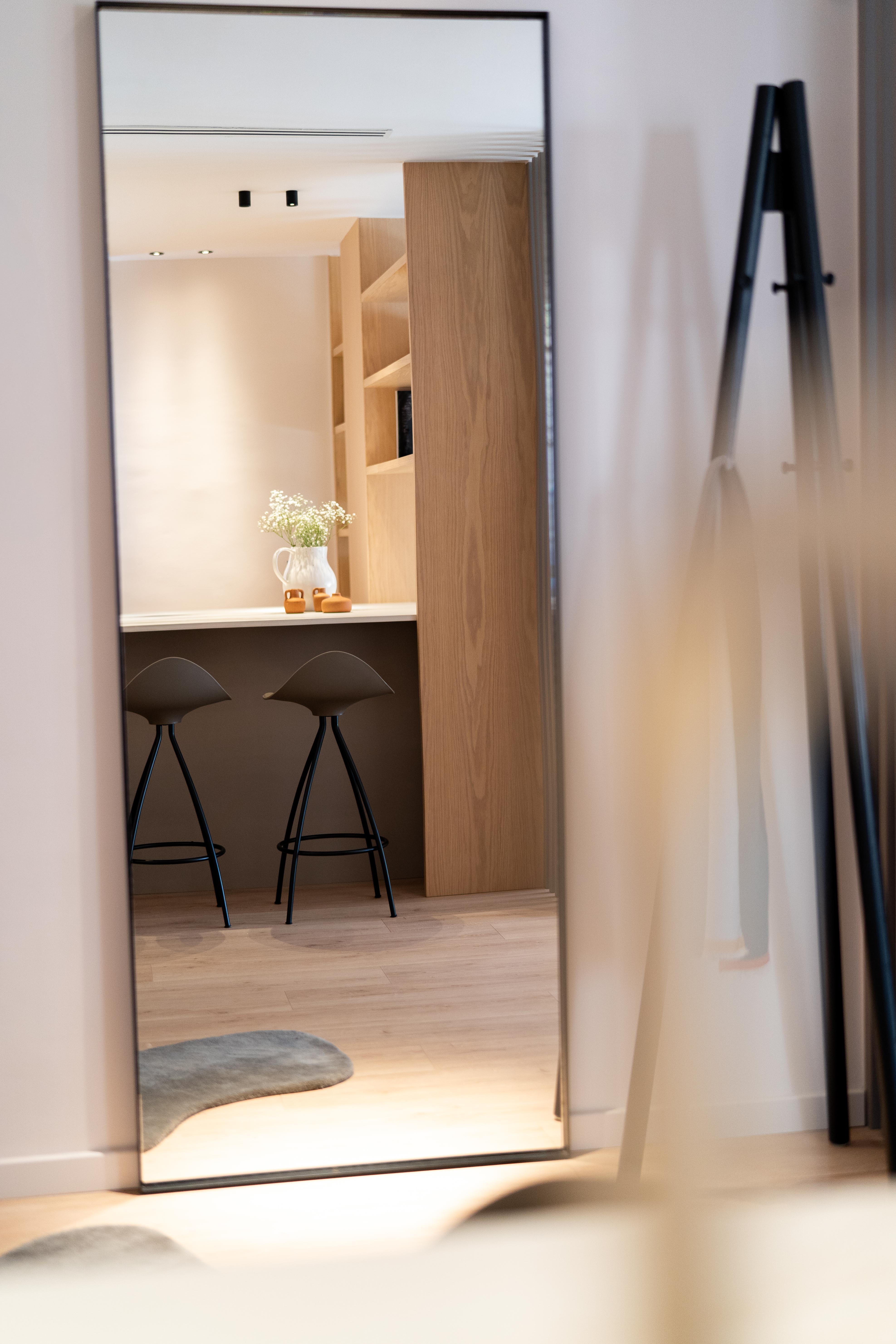 Espejo con reflejo de isla de cocina con taburetes