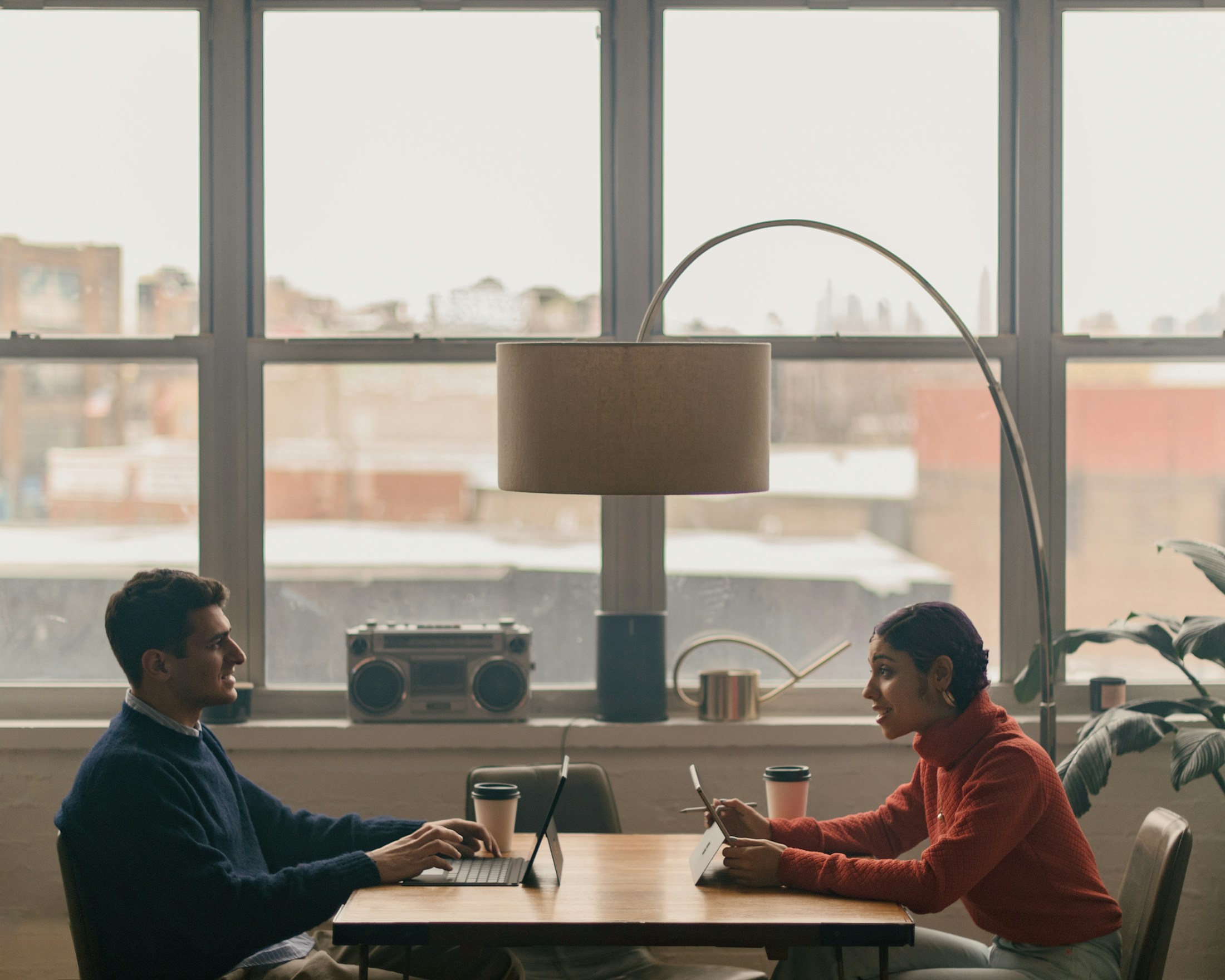 Two business partners in conversation at a sunlit table