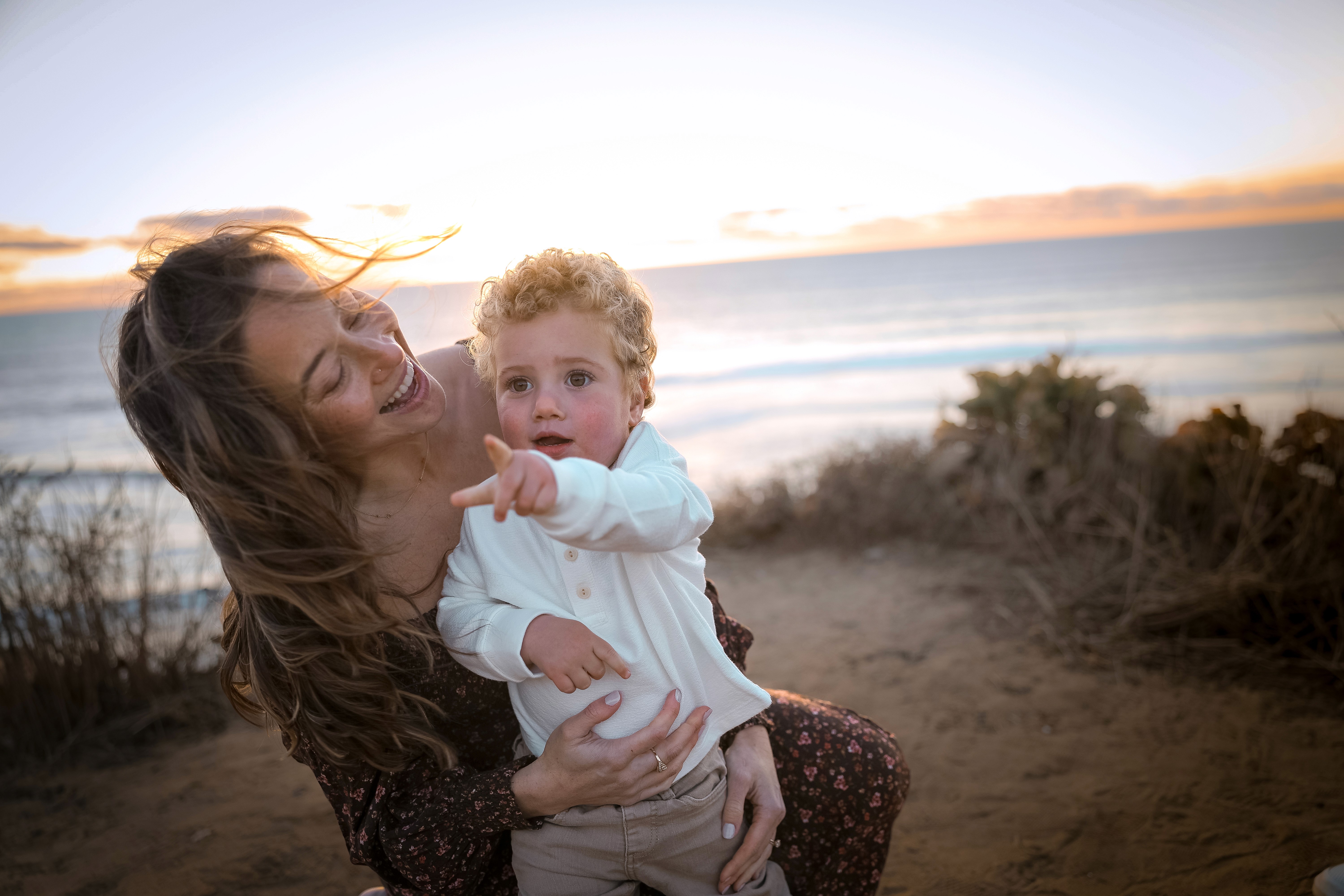 Mom hugging her little son closely during a sunset family session in San Diego.