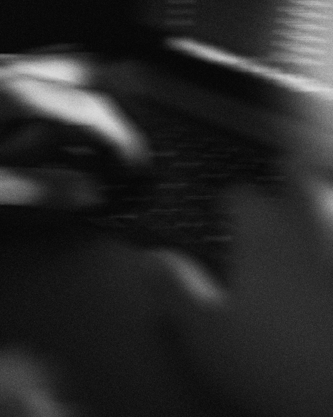 Spacious open-plan office with rows of desks and striking circular ceiling lights.