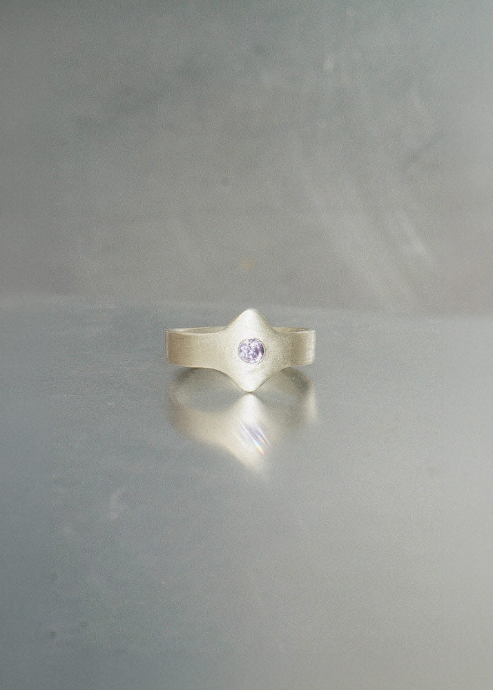 925 silver ring with a purple gemstone on a gray background