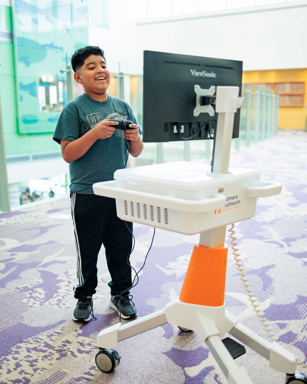 A child plays games on a GO Kart while standing.