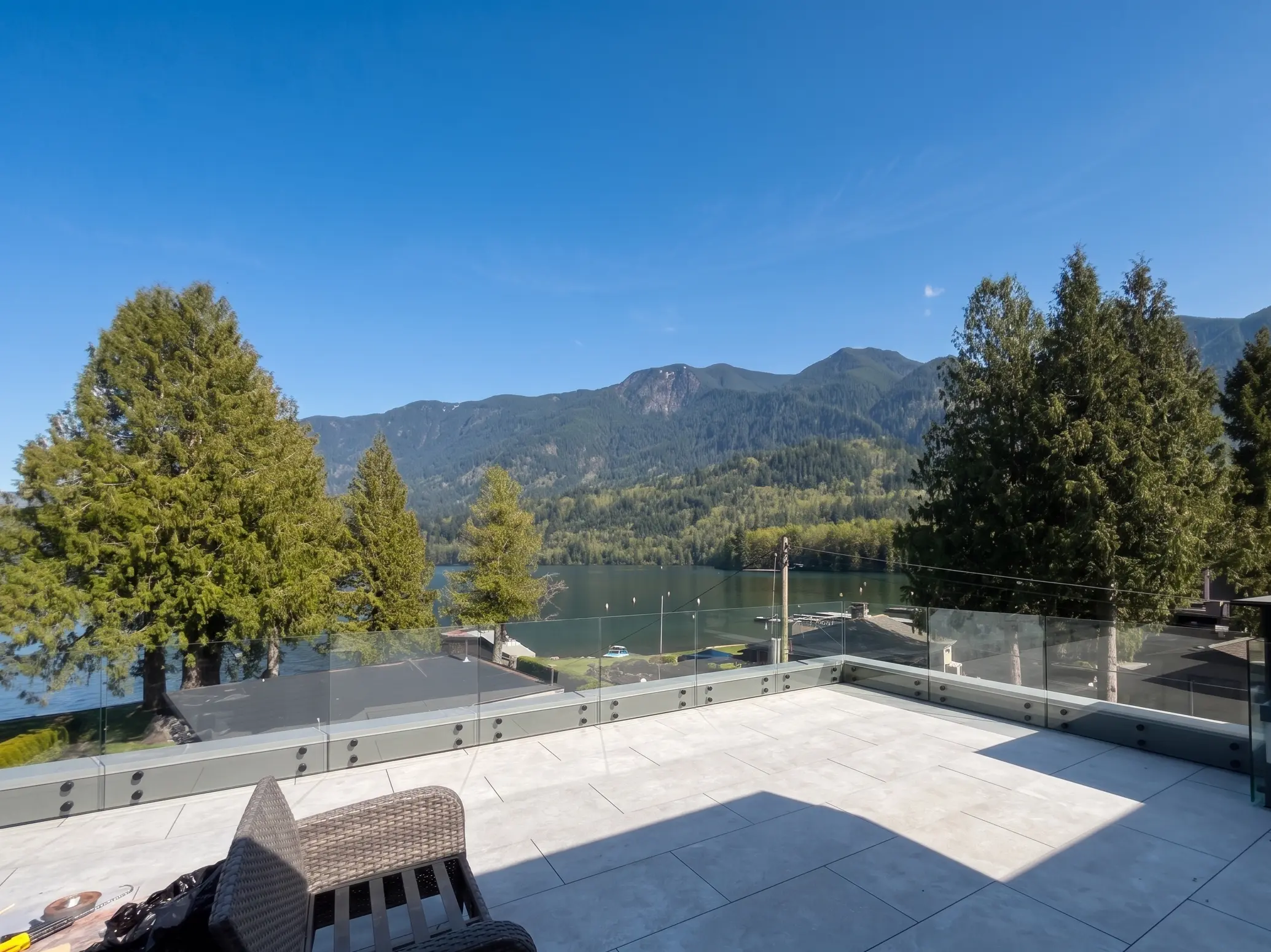 Semi-frameless glass railing on a rooftop deck at a strata building with mountain views near Comox