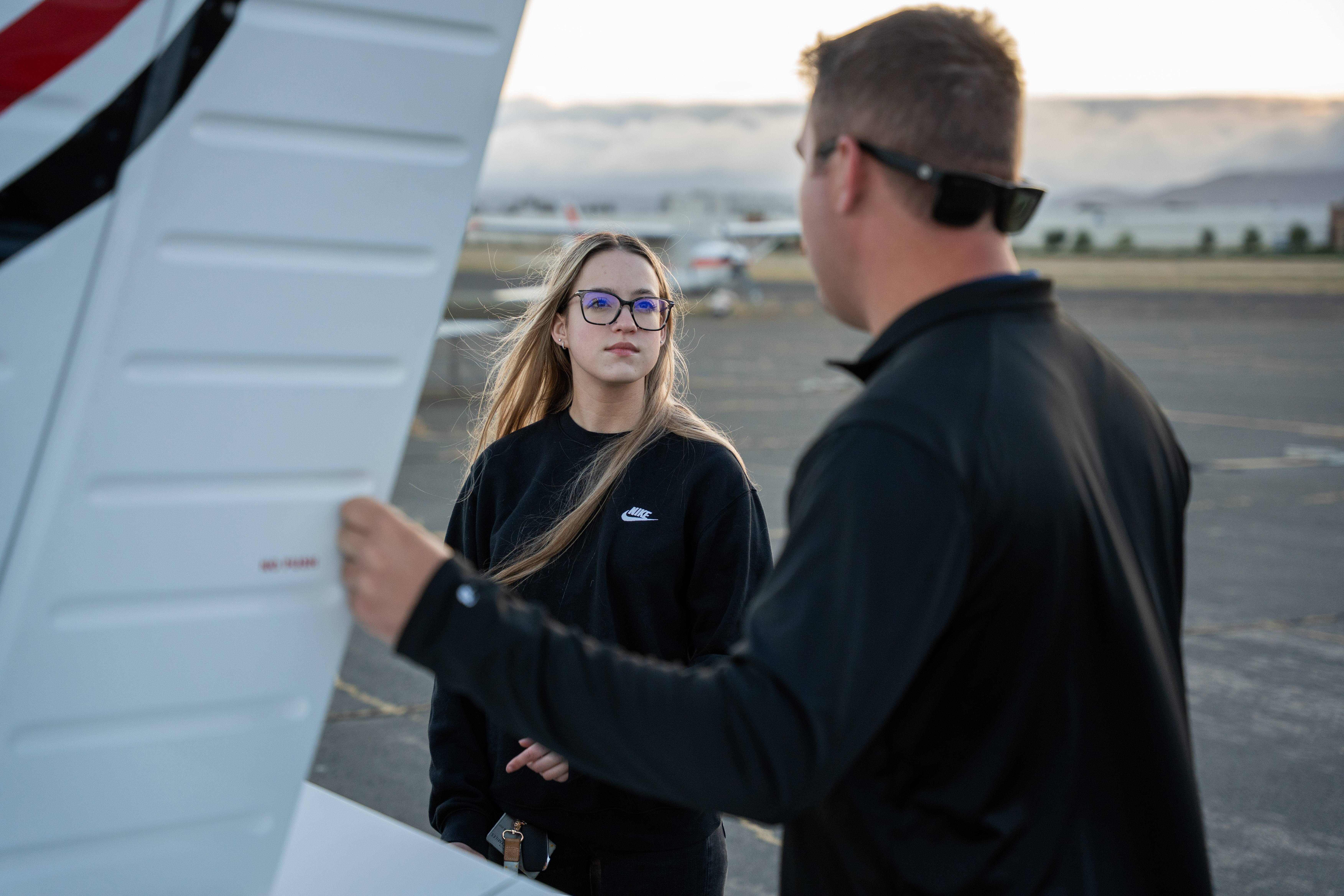 A close-up of a black credit card placed on a speckled surface next to a cup of coffee.