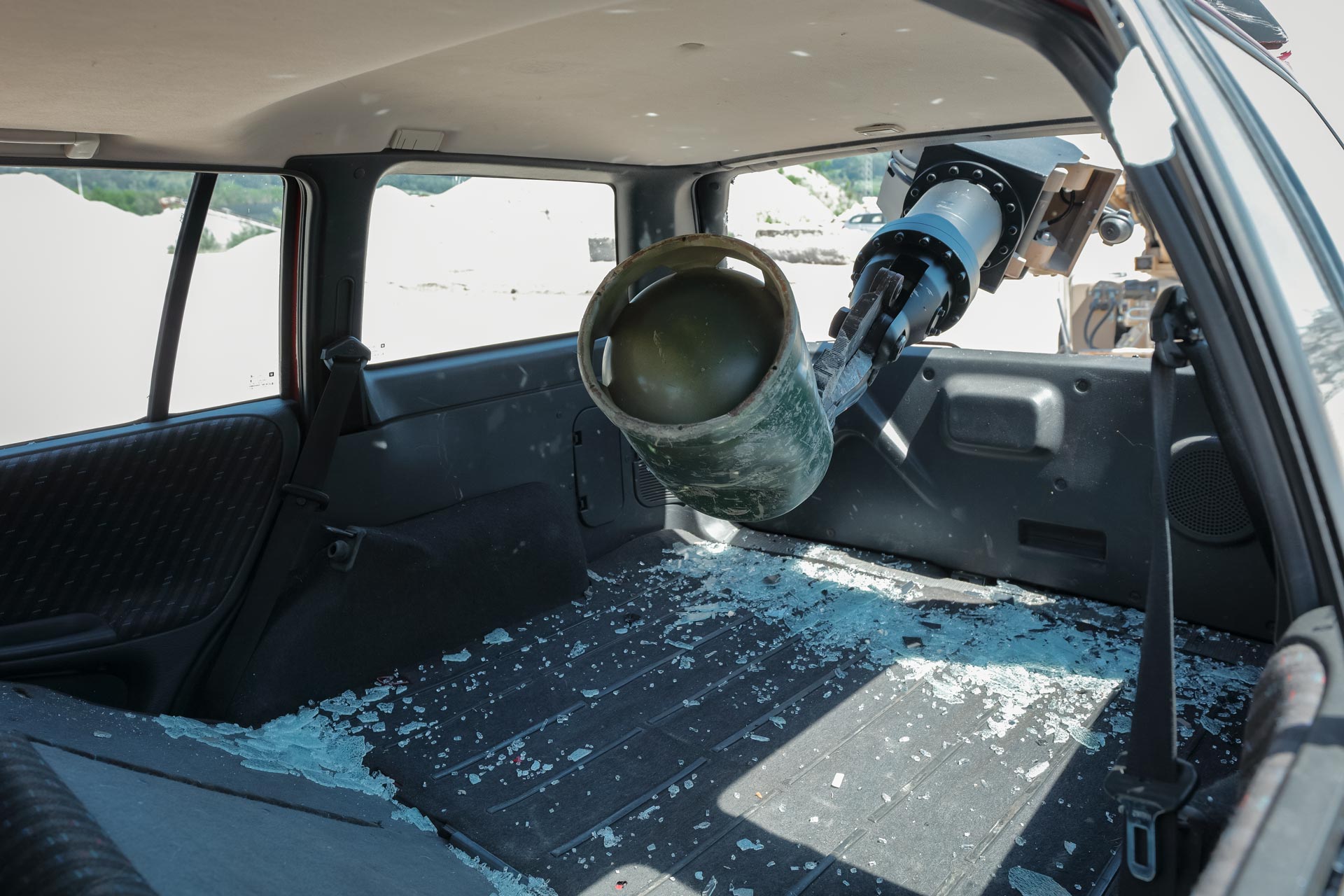 GCS manipulator arm searching a vehicle and recovering a suspicious device during IEDD operations.