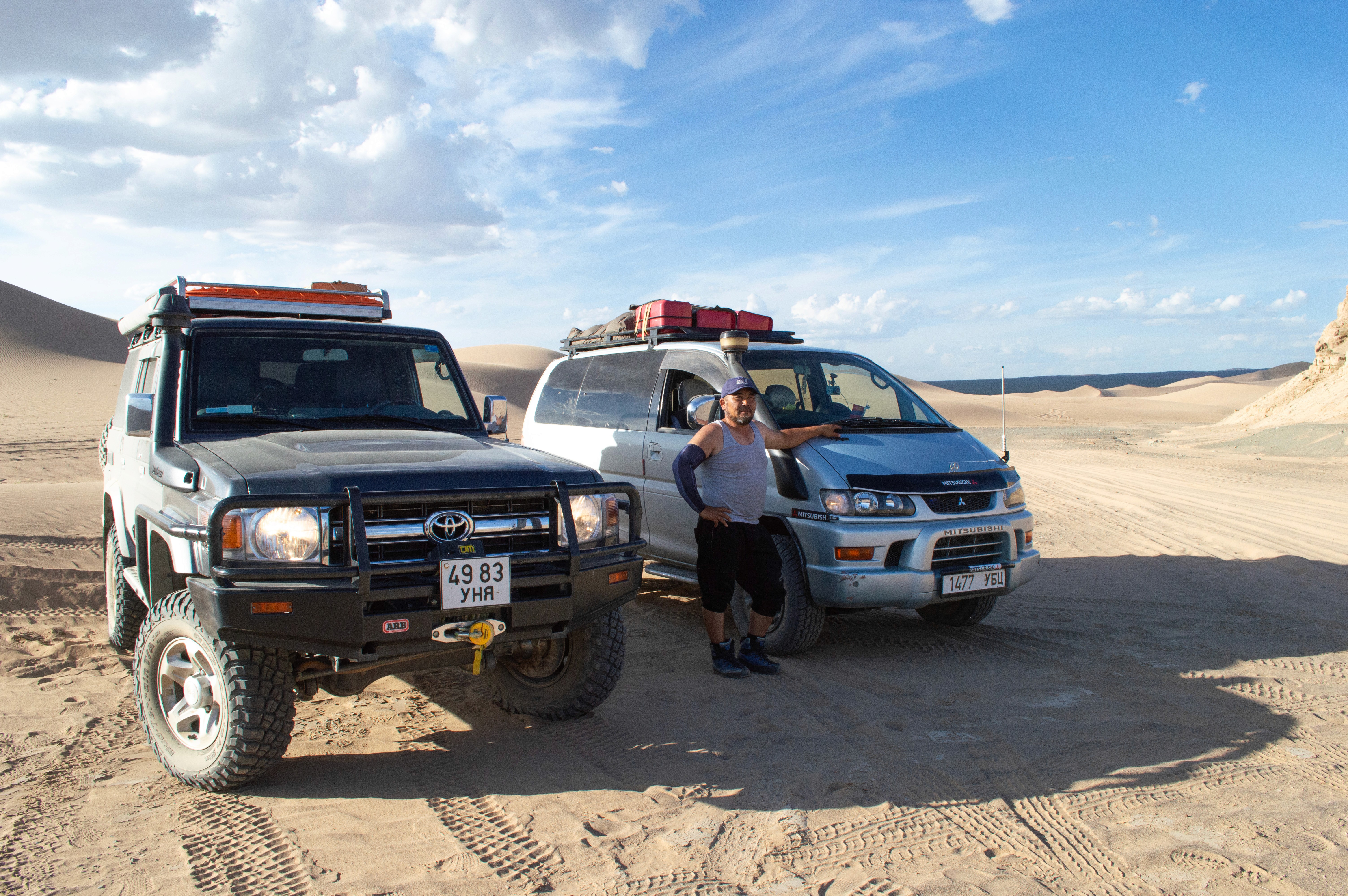 Tourguide and off-road car in Mongolian Gobi desert