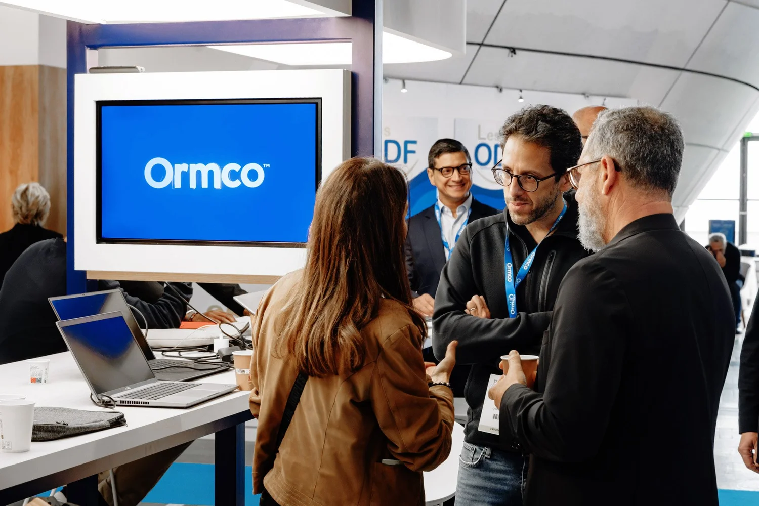 Professionnels en discussion sur le stand Ormco lors d’un salon professionnel