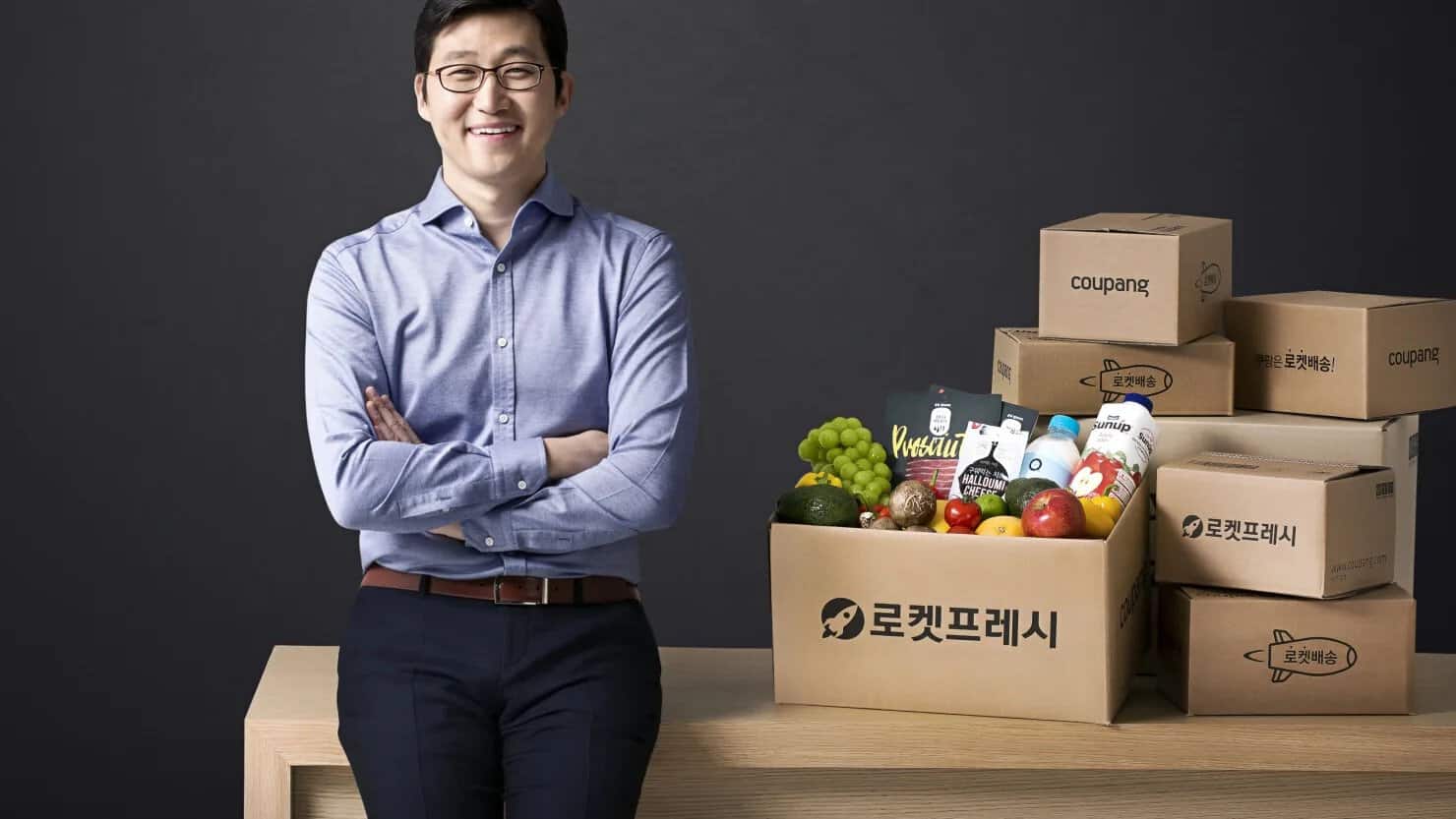 Kim Beom Seok, người sáng lập Coupang Hàn Quốc chụp ảnh trước những hộp hàng Rocket Fresh.