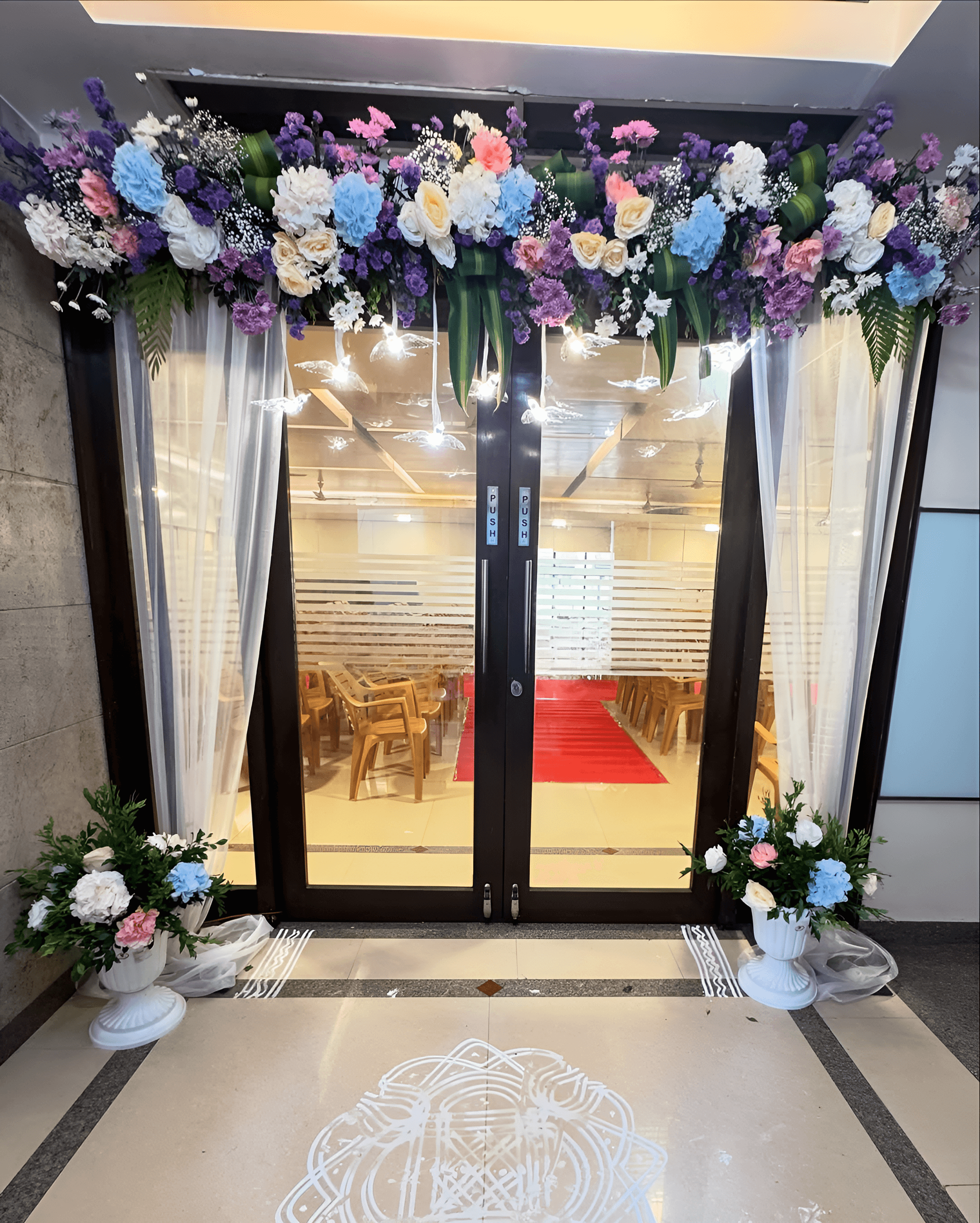 Engagement entrance decor with flowers in purple, blue, & pink at hall entrance in Raj Nagar Extension, Ghaziabad & Delhi NCR