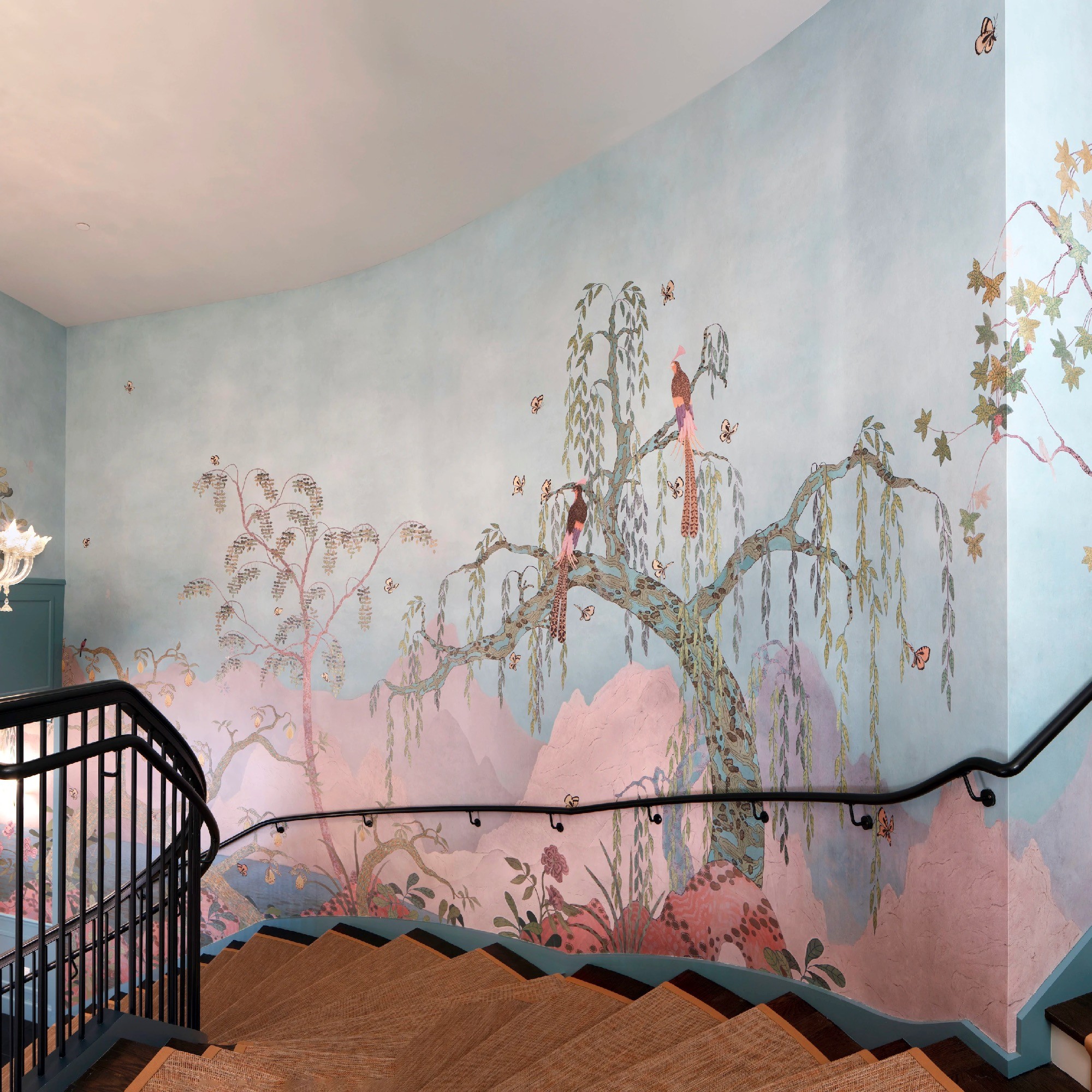 Whimsical nature mural installed on staircase wall.