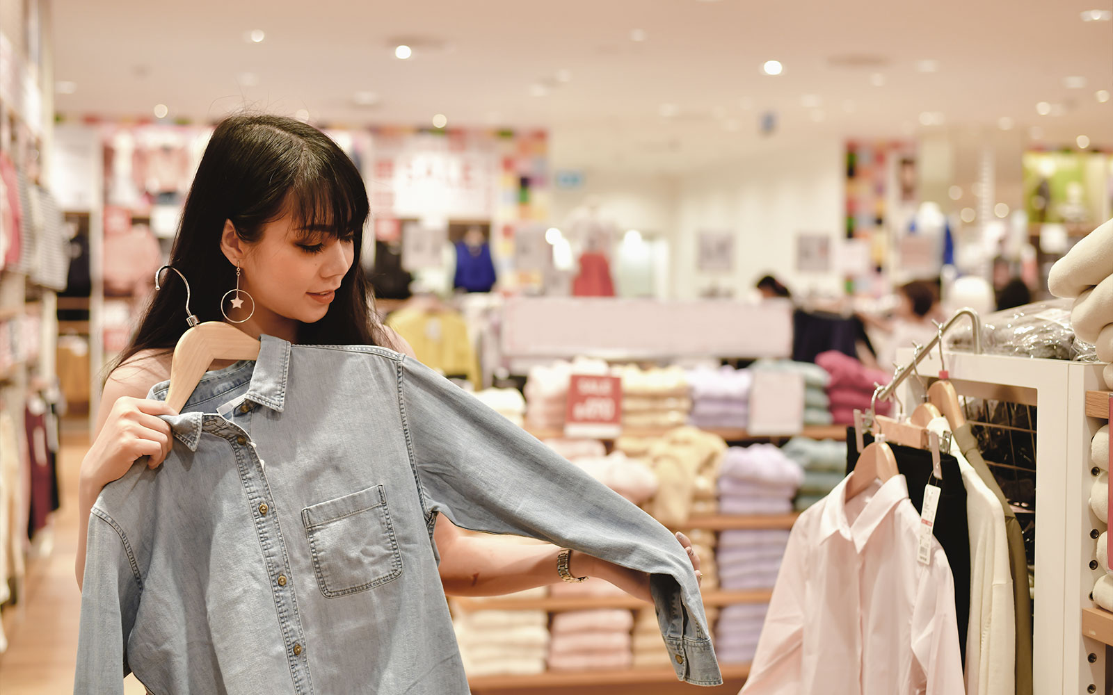 Ψώνια στο κατάστημα του Οκινάουα, γυναίκα κρατάει τζιν πουκάμισο.