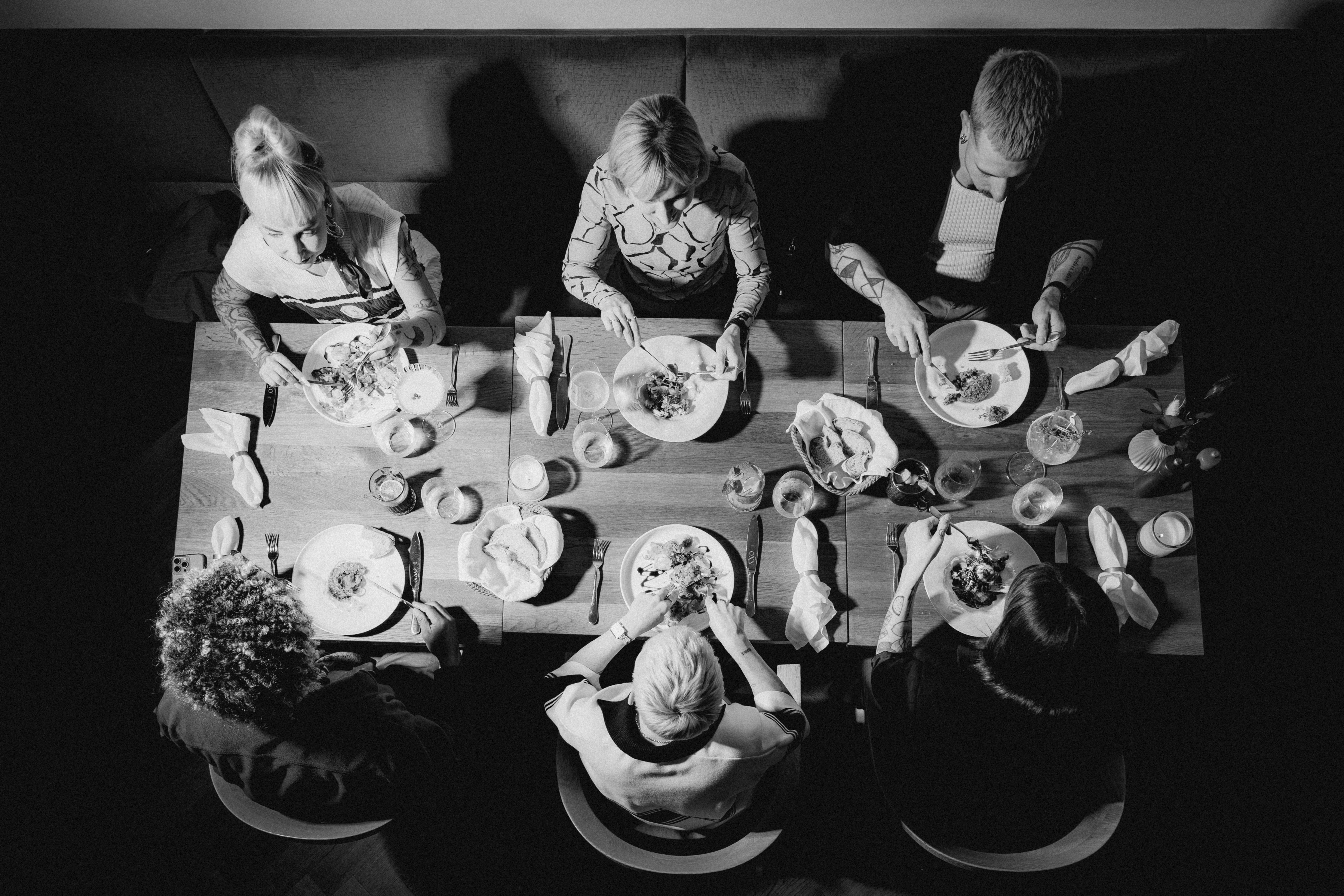 A person walks through a narrow hallway lined with shelves, surrounded by framed photographs in black and white.
