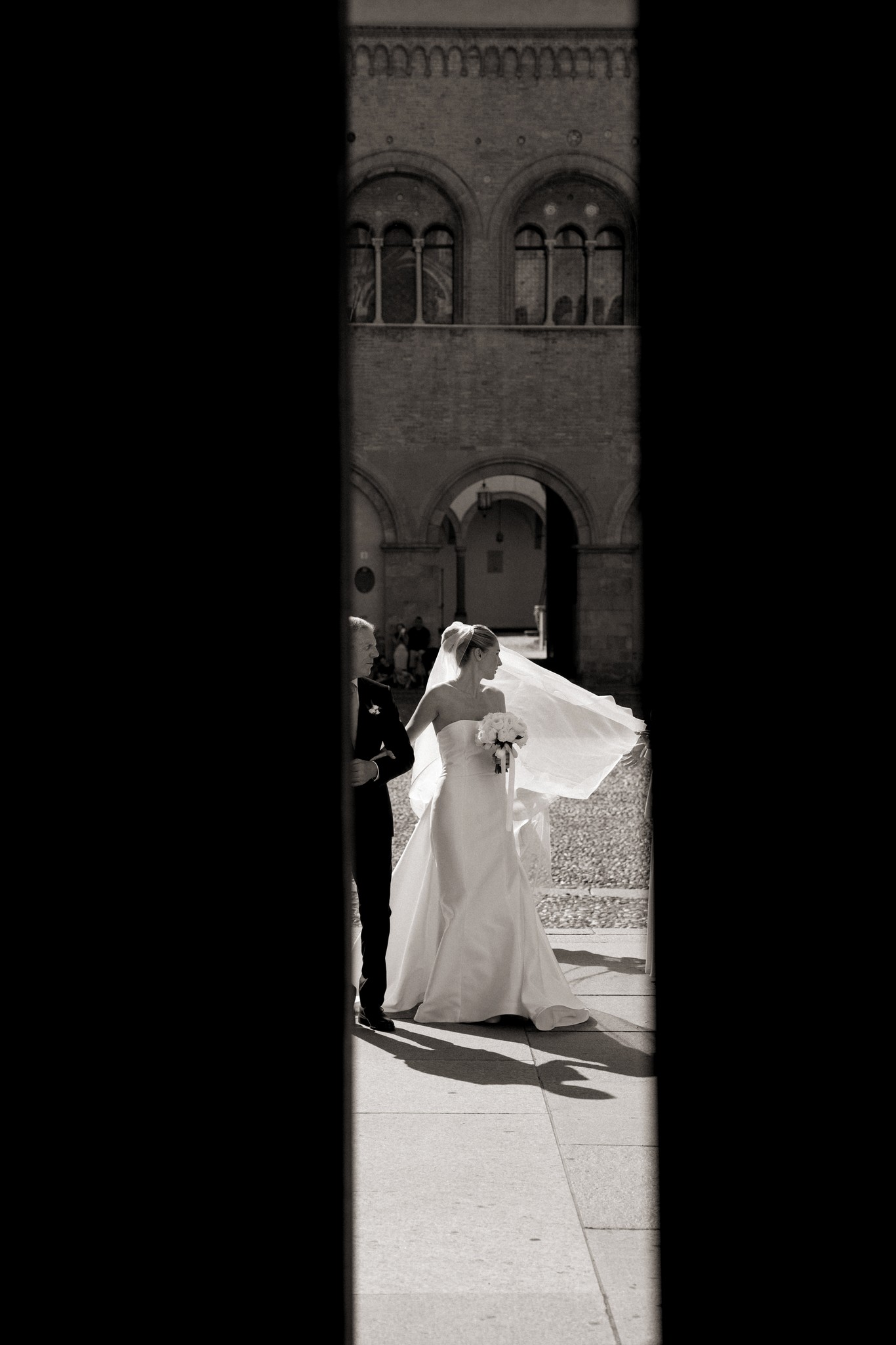 Sposa al sole davanti alla torre medievale di Villa Malenchini, velo mosso dal vento, reportage matrimoniale