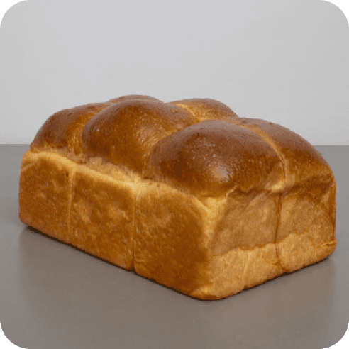 Pan brioche de masa madre moldeado, con acabado dorado parejo y volumen perfecto.