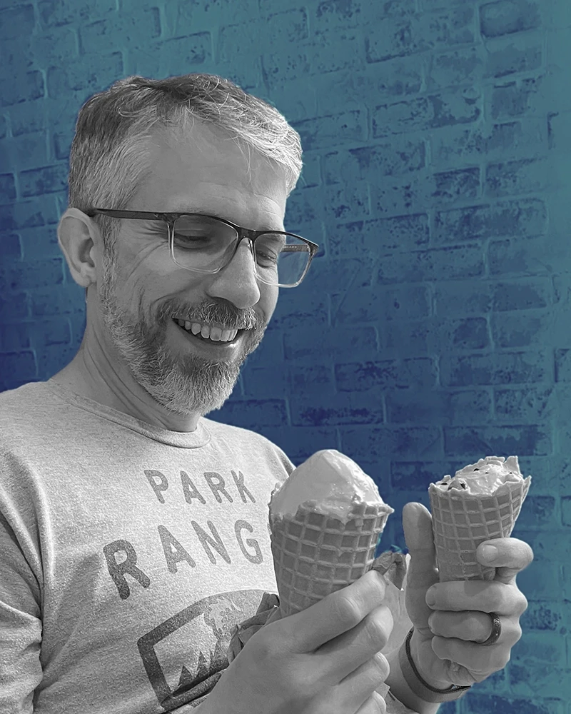 Portrait of Jonathan Coen wearing a collared shirt and jacket