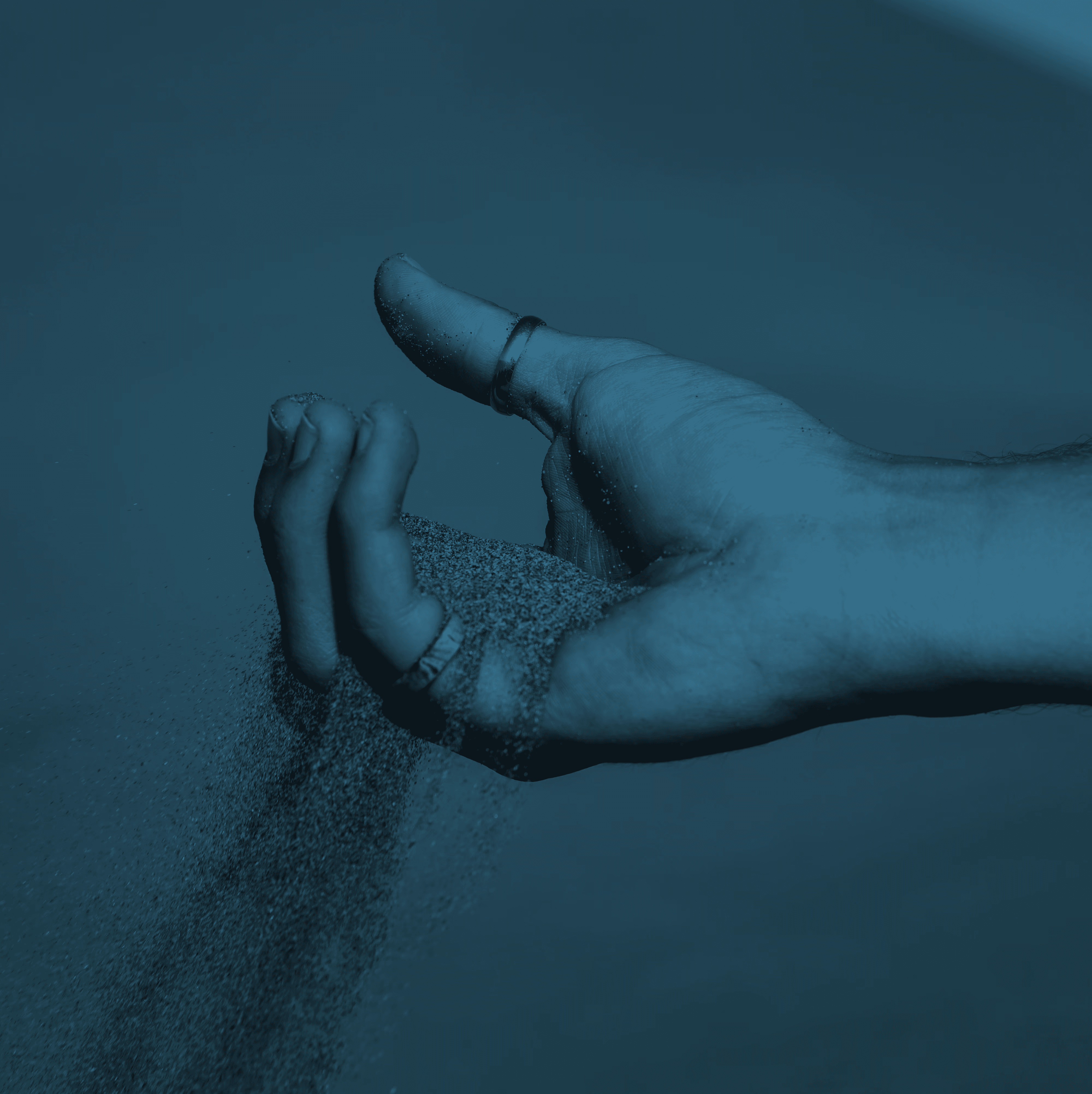 a person holding sand in their hand on the beach